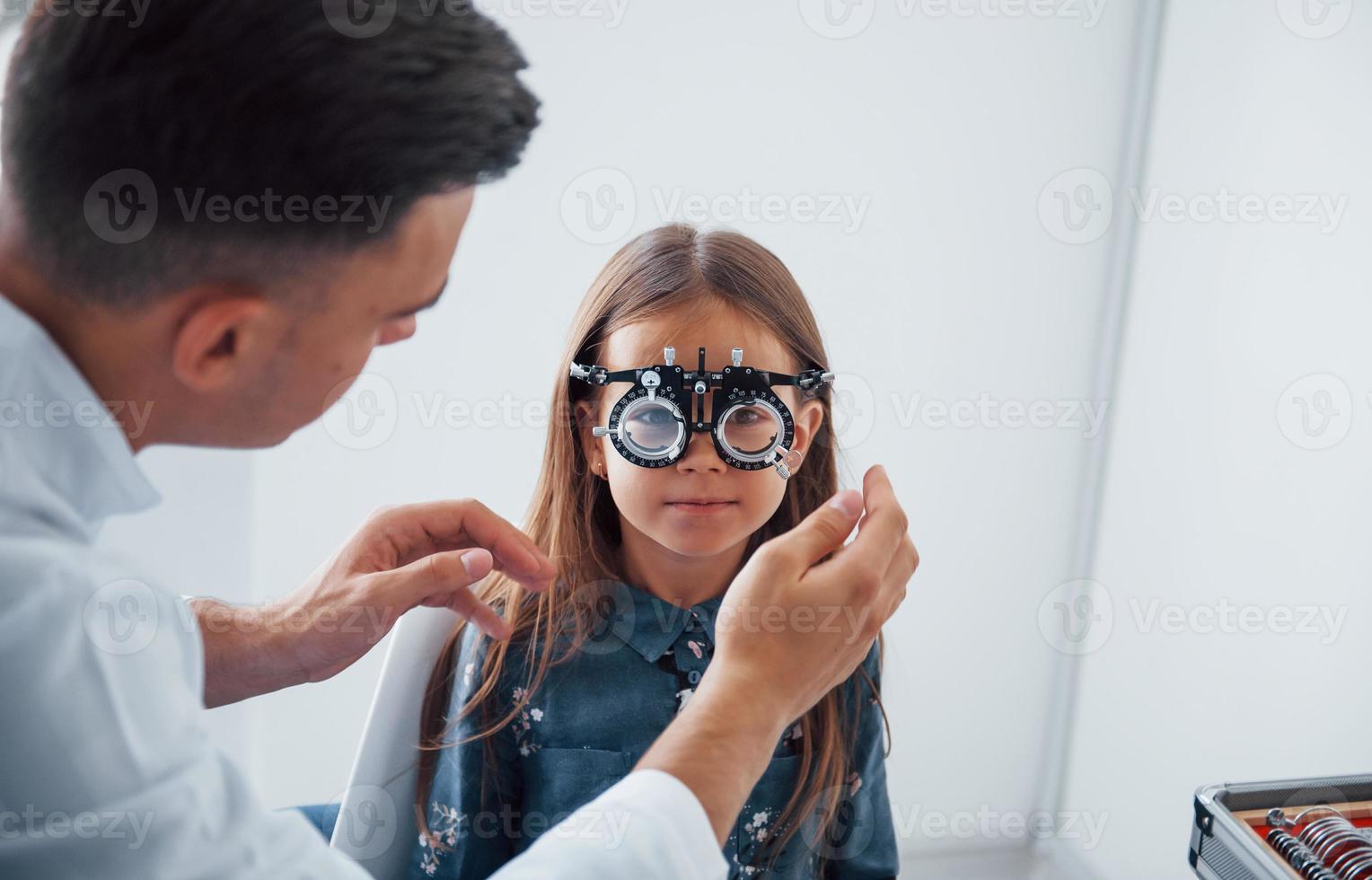 analisi visione. giovane oculista è con poco femmina visitatore nel il clinica foto