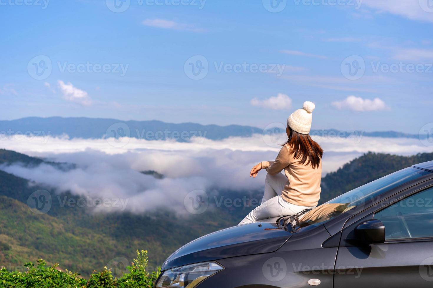 viaggiatori di giovani donne con l'auto che guardano un bellissimo mare di nebbia sulla montagna mentre viaggiano guidando un viaggio su strada in vacanza foto