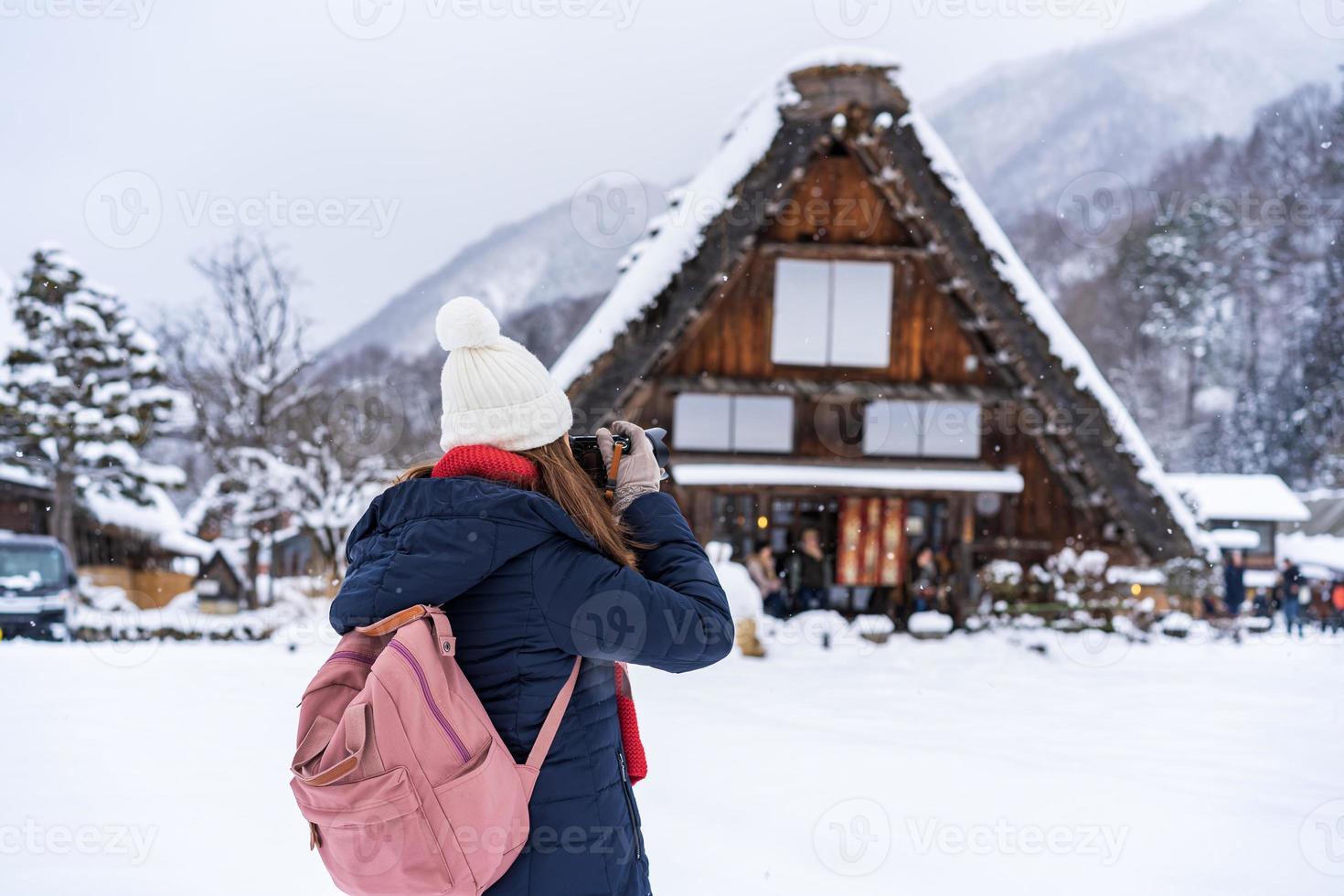 giovane donna viaggiatore godendo con neve a shirakawa-go nel inverno foto