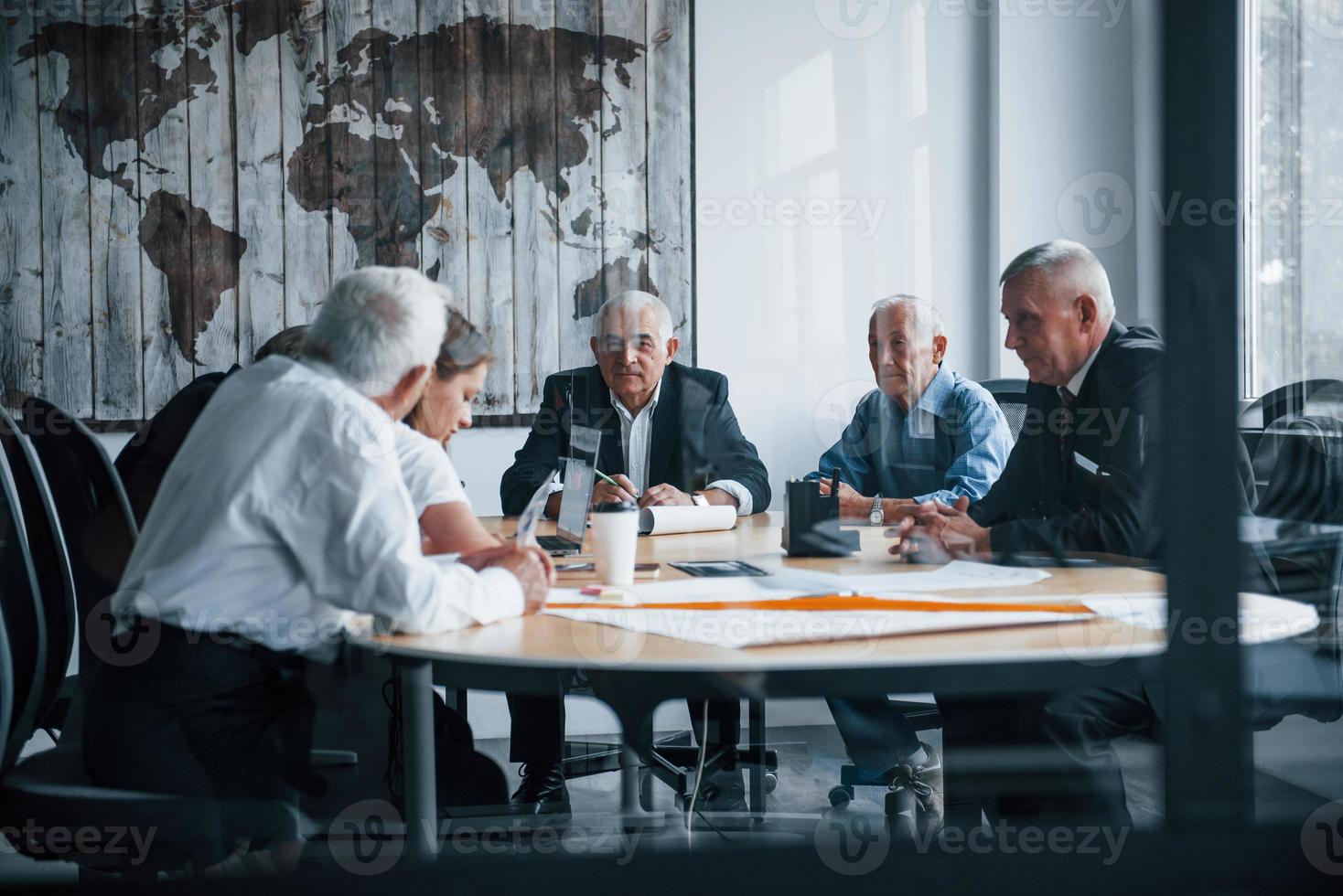 anziano squadra di anziano uomo d'affari architetti avere un' incontro nel il ufficio e lavori con giovane donna foto