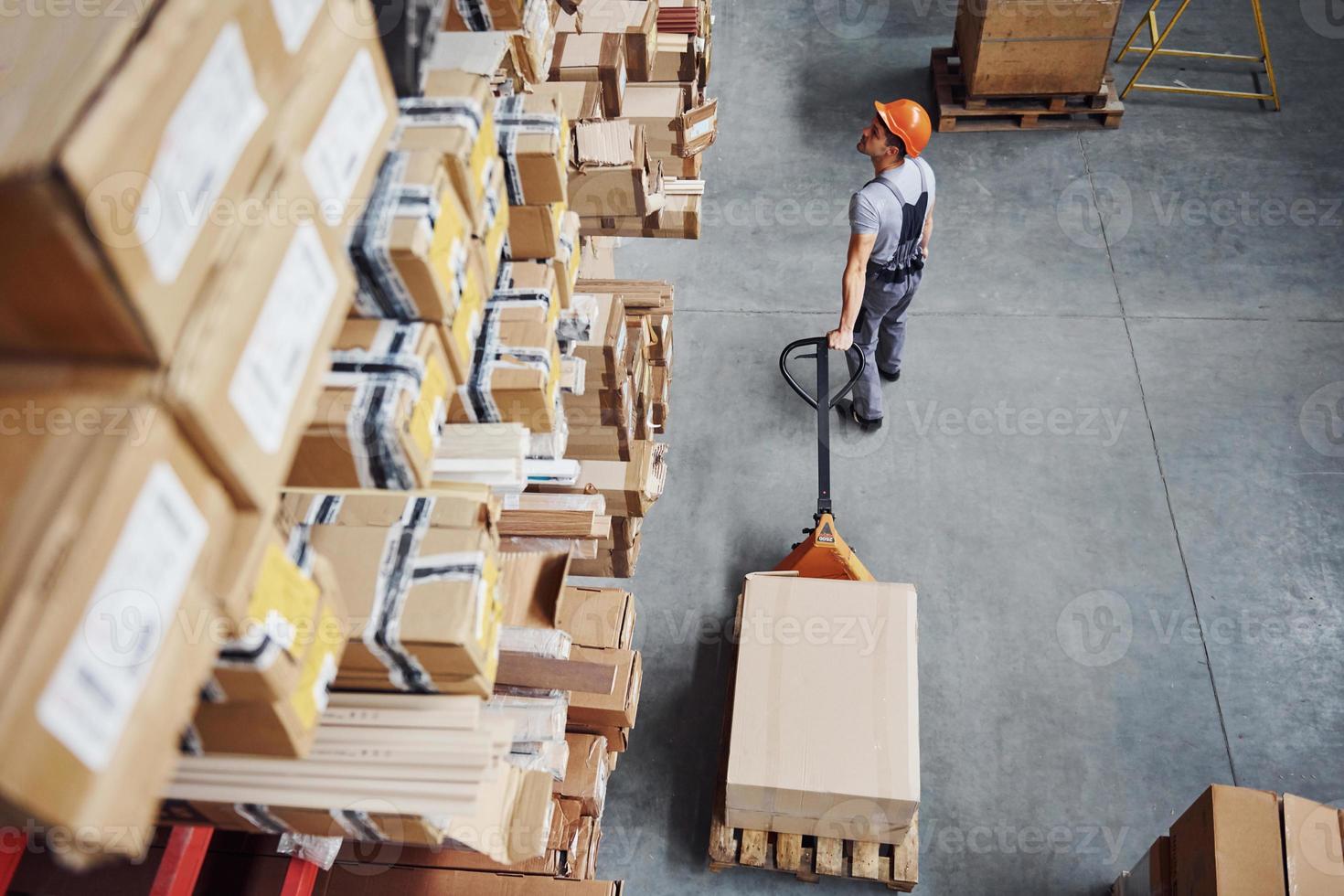 superiore Visualizza di maschio lavoratore nel magazzino con pallet camion foto