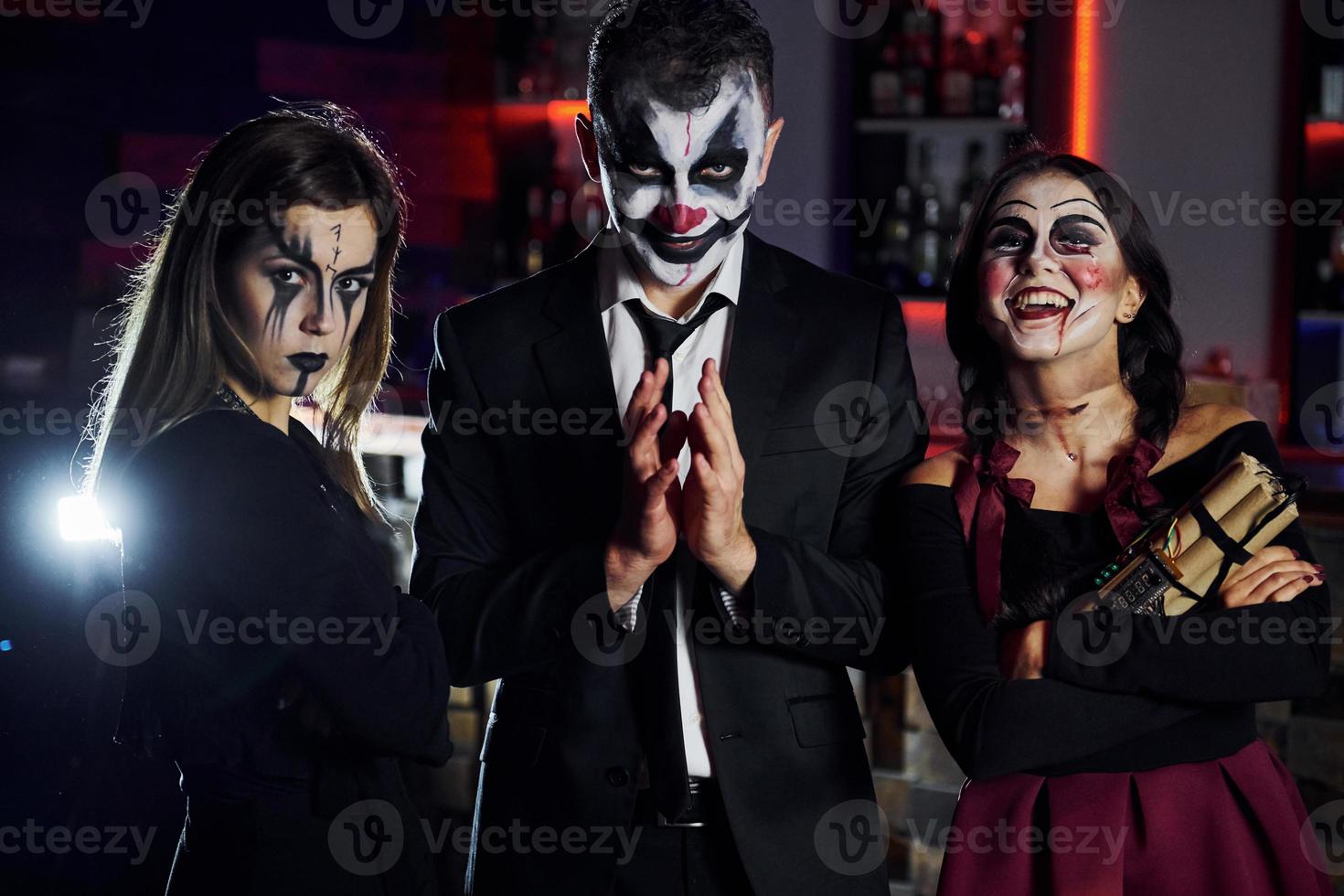 amici è su il tematico Halloween festa nel pauroso trucco e costumi avere divertimento e in posa per il telecamera insieme foto