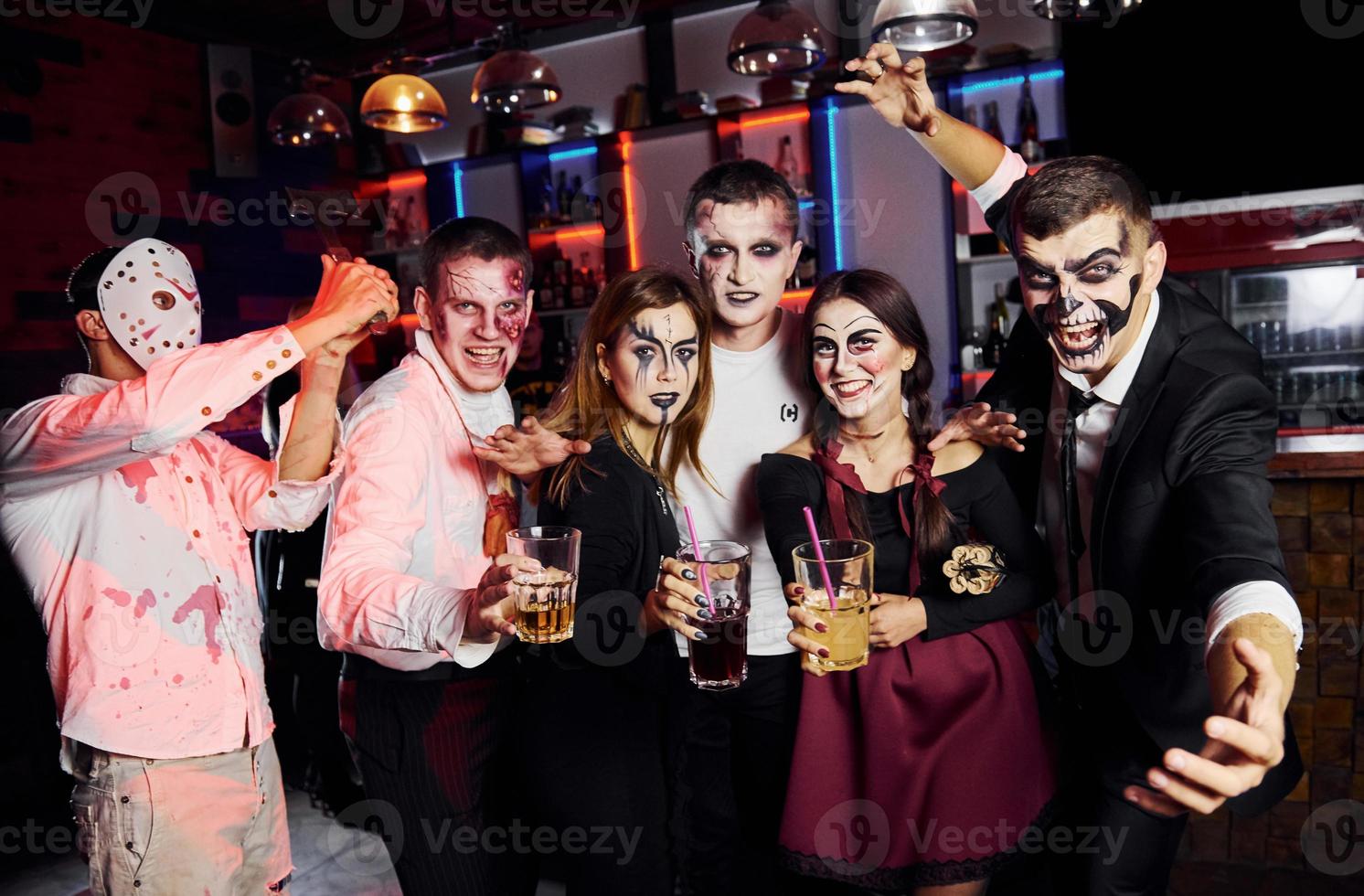 in posa per il telecamera. amici è su il tematico Halloween festa nel pauroso trucco e costumi foto