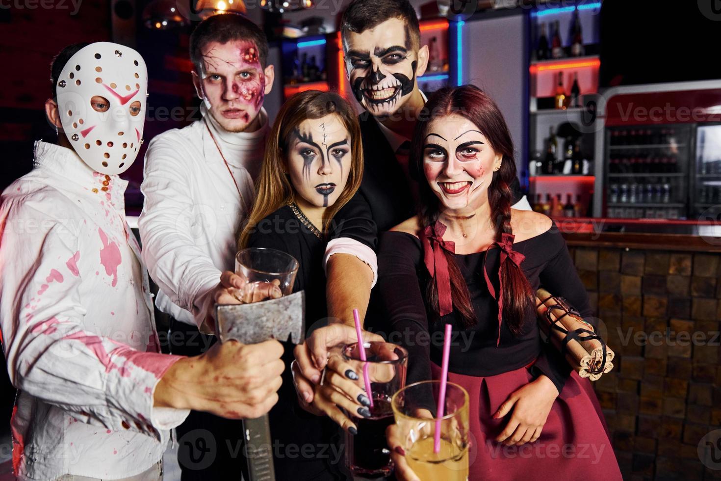 in posa per il telecamera. amici è su il tematico Halloween festa nel pauroso trucco e costumi foto