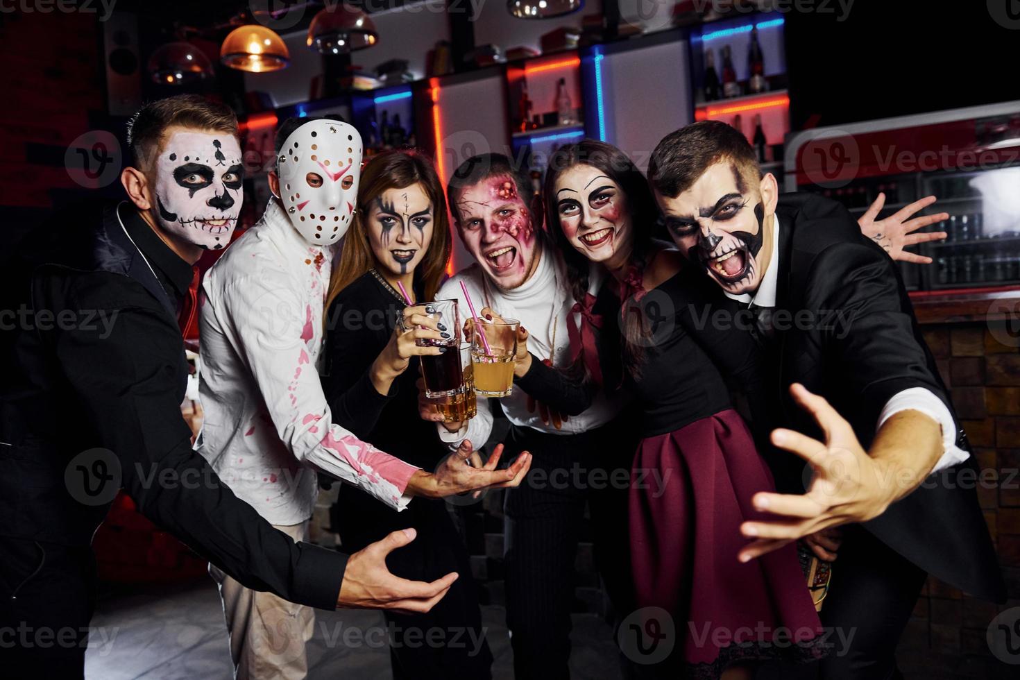 in posa per il telecamera. amici è su il tematico Halloween festa nel pauroso trucco e costumi foto