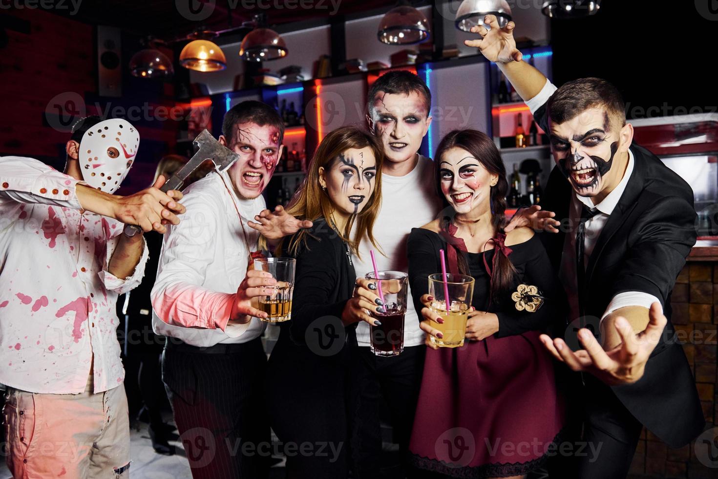 in posa per il telecamera. amici è su il tematico Halloween festa nel pauroso trucco e costumi foto