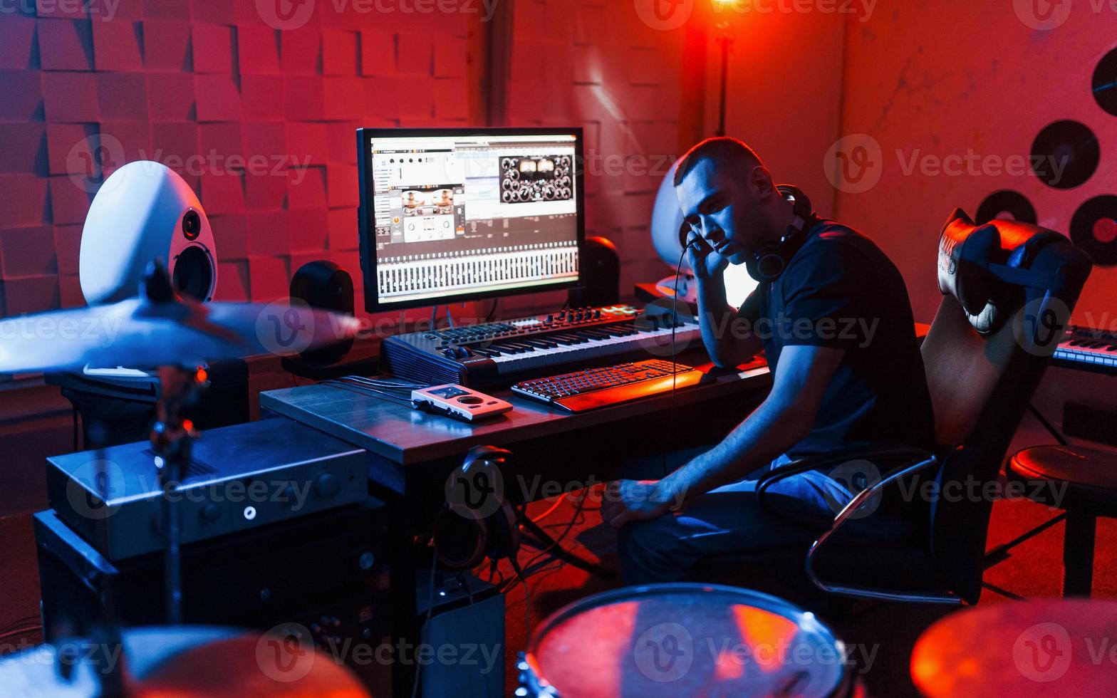 suono ingegnere Lavorando e miscelazione musica in casa nel il studio vicino tamburo kit foto