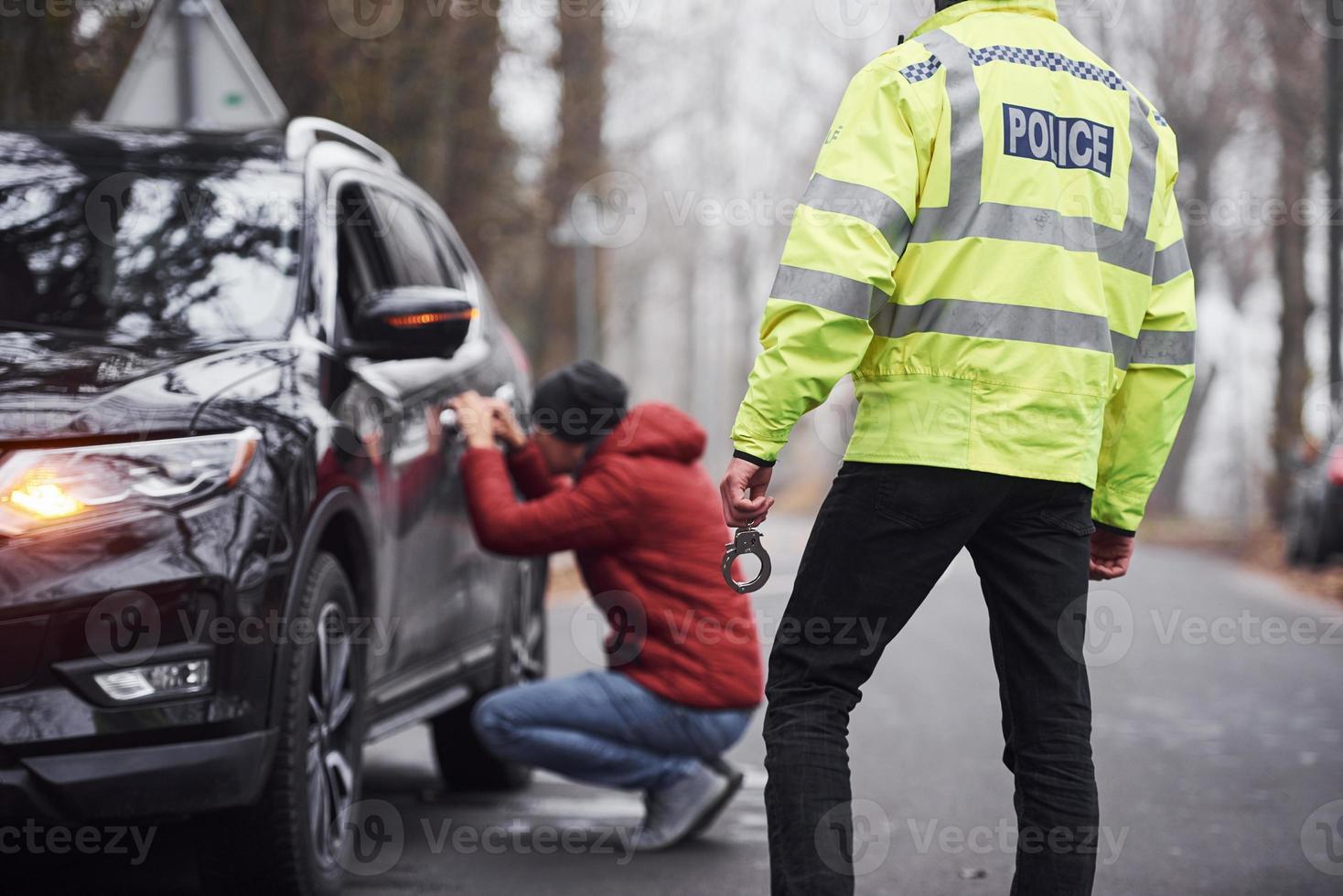 polizia ufficiale nel verde uniforme catturato automobile furto su il strada foto