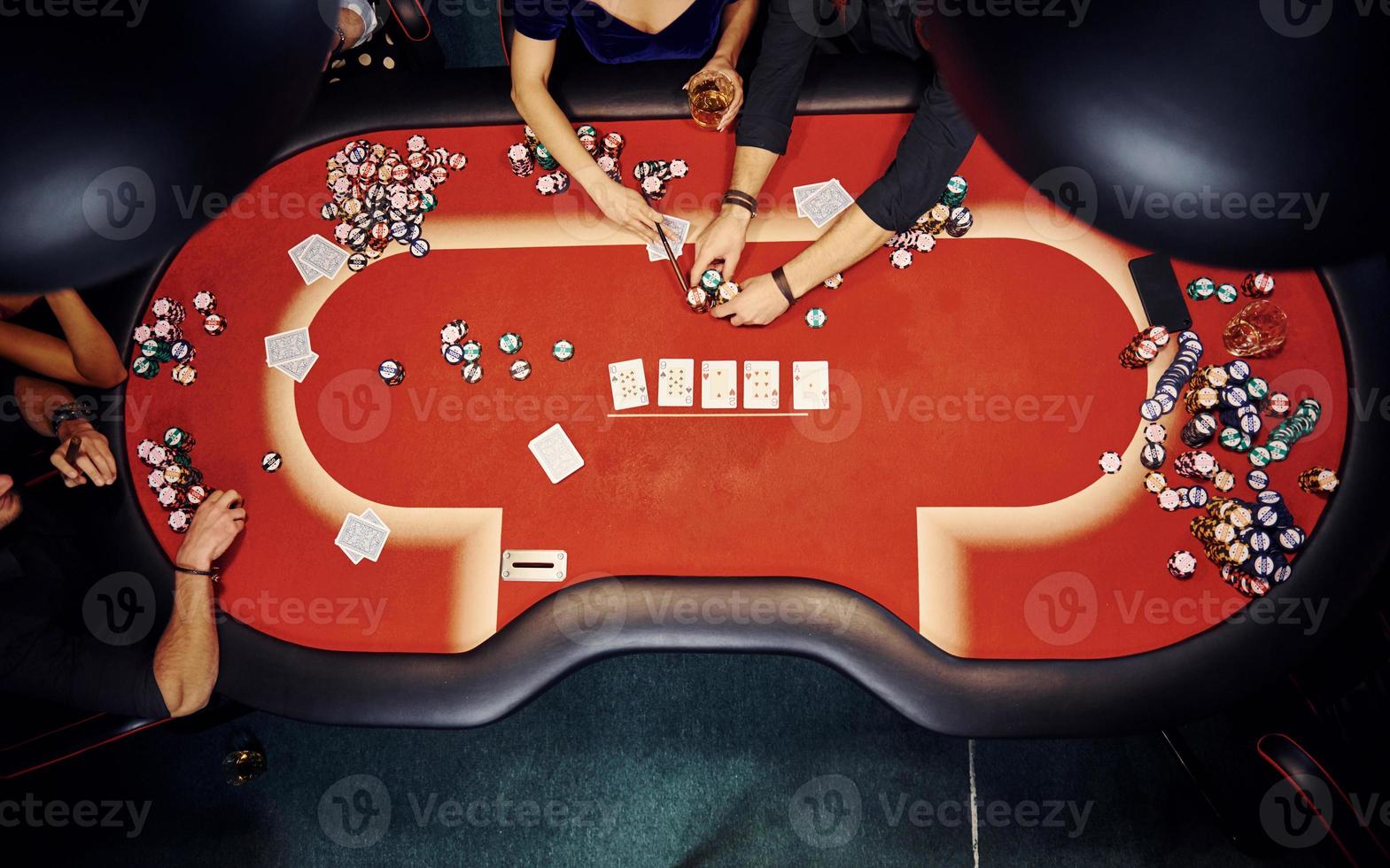 superiore Visualizza di elegante giovane persone quello giocando poker nel casinò foto