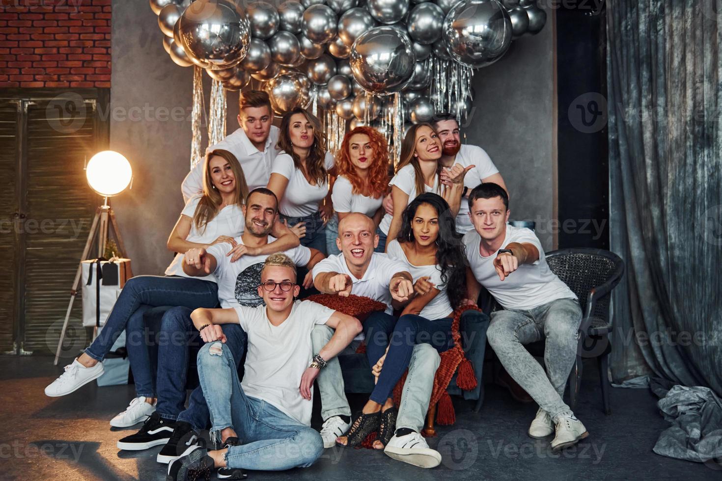 positivo giovane persone seduta e festeggiare nuovo anno nel Natale decorato camera con palloncini insieme foto