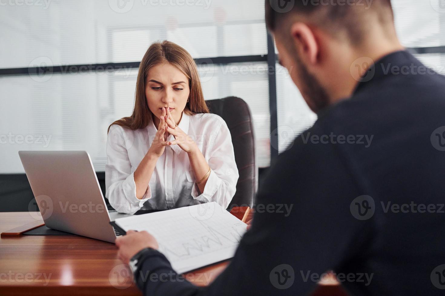 tipo seduta con documenti. donna e uomo nel formale Abiti Lavorando insieme in casa nel il ufficio di tavolo foto