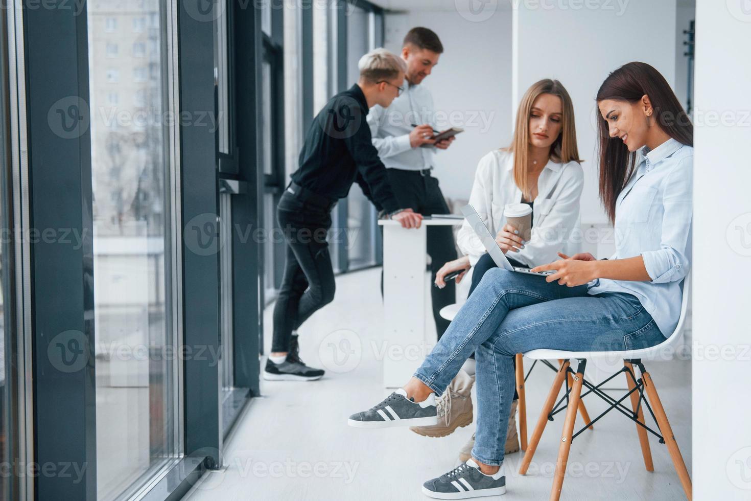 gruppo di giovane riuscito squadra seduta e Lavorando insieme in casa nel ufficio con documenti e il computer portatile foto