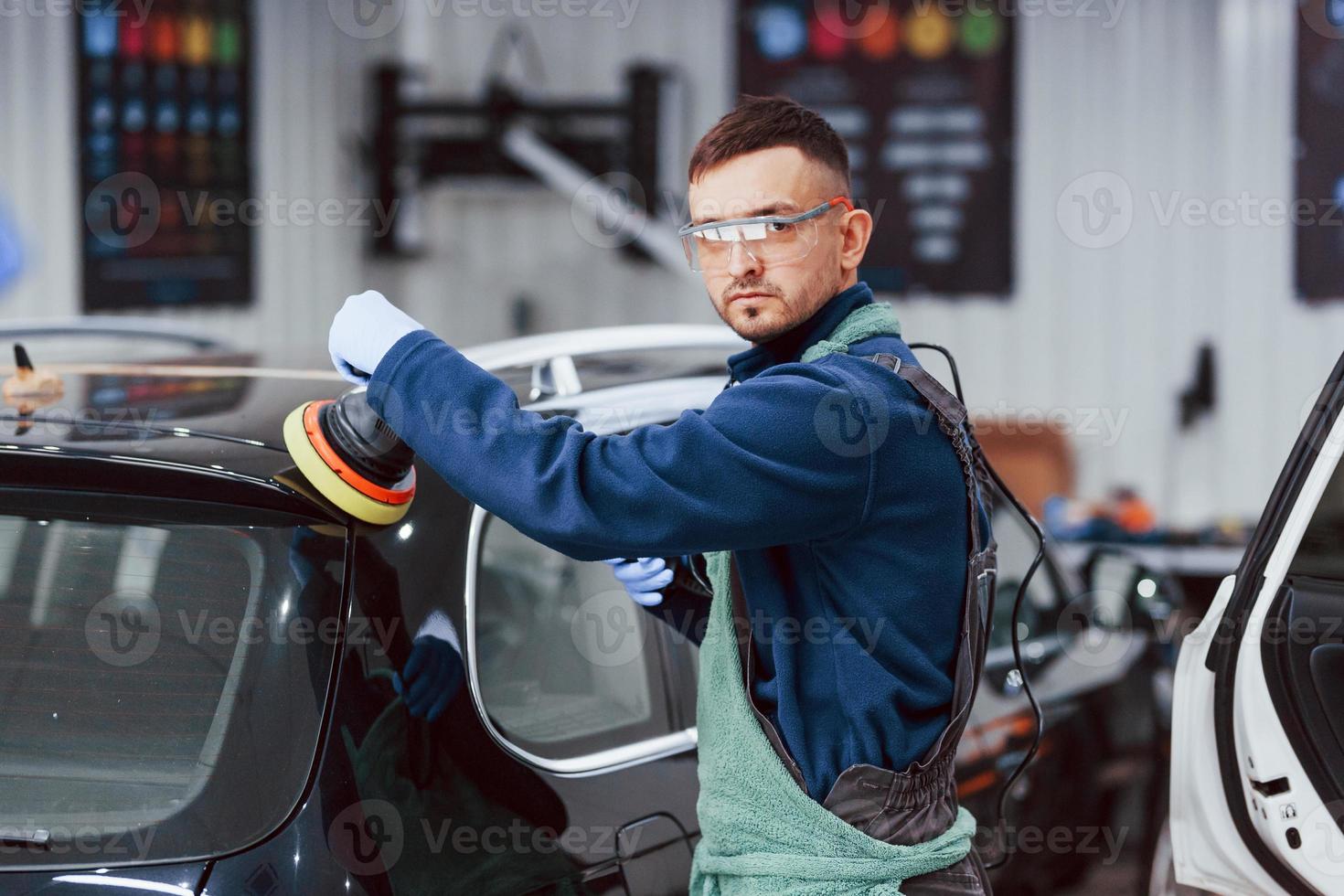 maschio lavoratore nel uniforme lucidatura nuovo moderno macchina. concezione di servizio foto