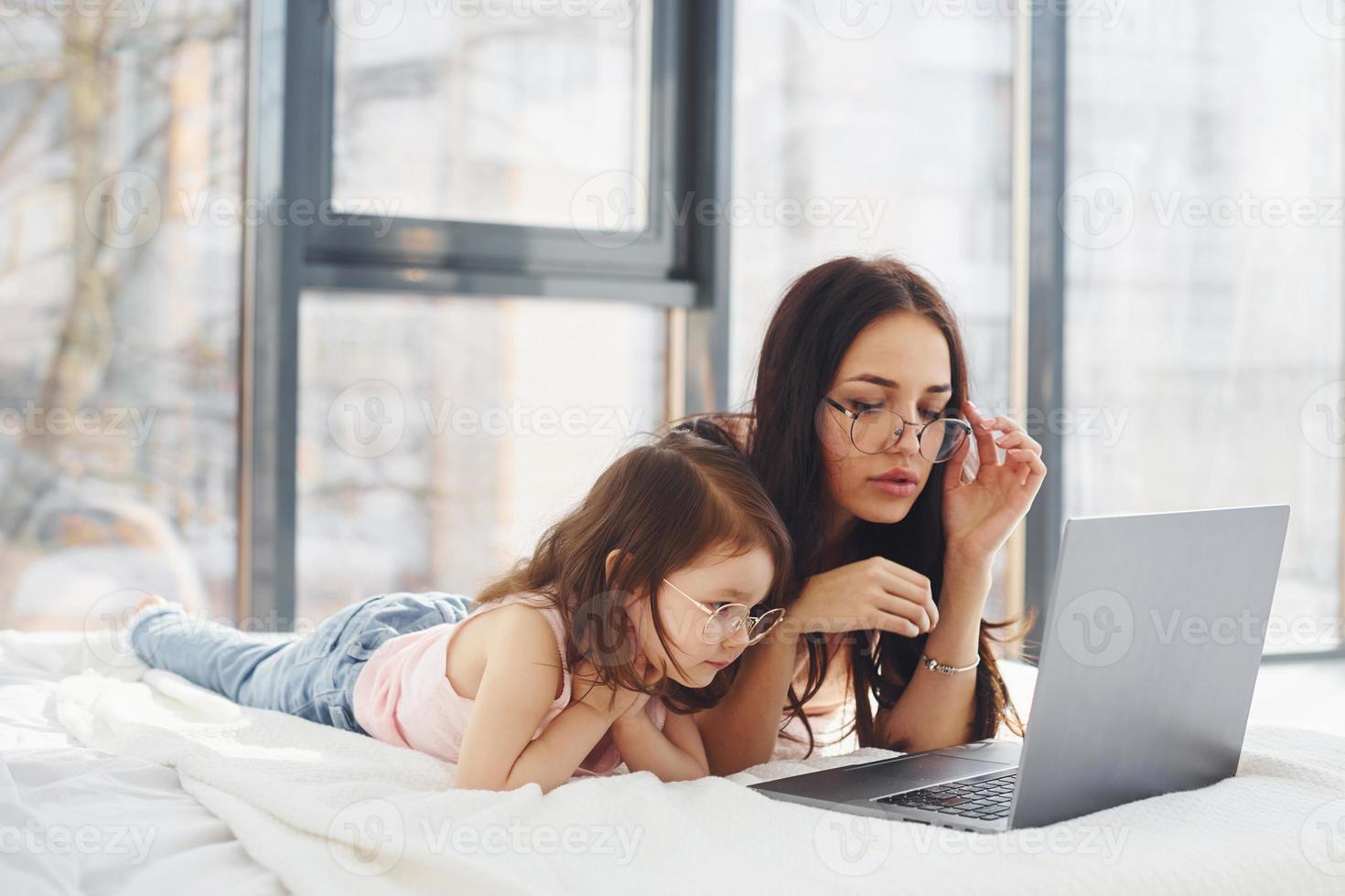 giovane madre con sua figlia la spesa fine settimana insieme nel camera e utilizzando il computer portatile foto