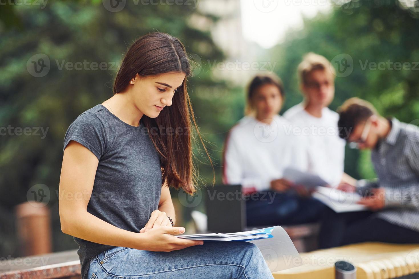 Lavorando a progetto. gruppo di giovane studenti nel casuale Abiti nel il città a giorno foto