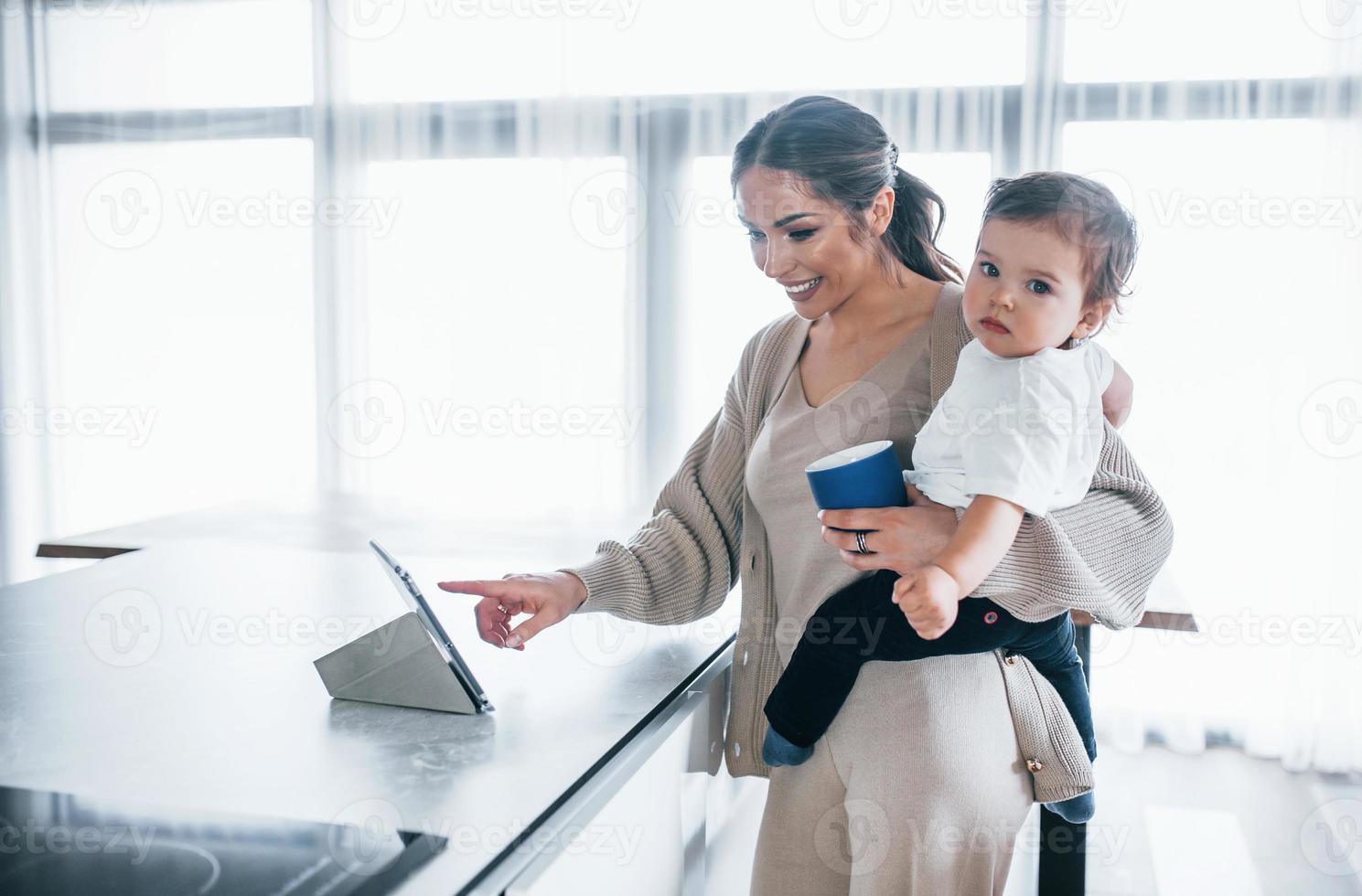 femmina blogger madre con sua ragazzo insieme in casa a casa a fine settimana utilizzando tavoletta foto
