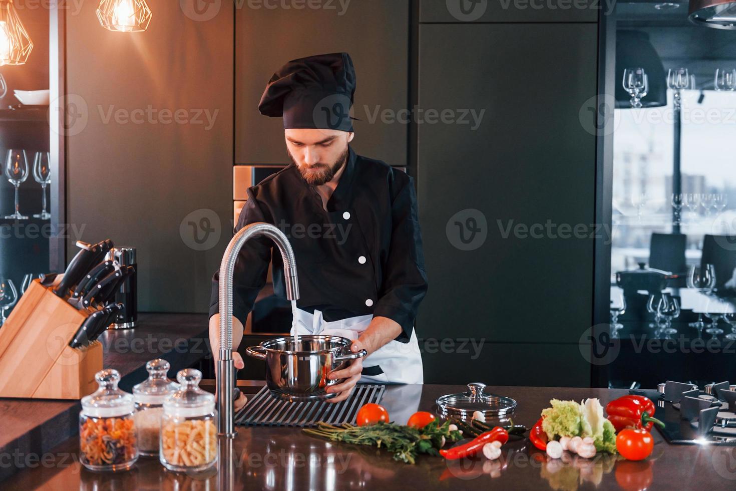 professionale giovane capocuoco cucinare nel uniforme avere un' occupato giorno su il cucina foto