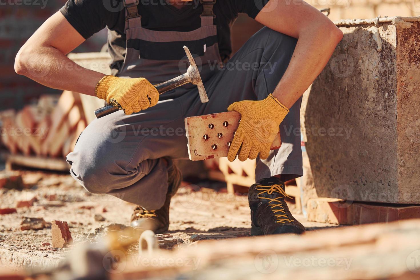 costruzione lavoratore nel uniforme e sicurezza attrezzatura si siede e avere lavoro su edificio foto