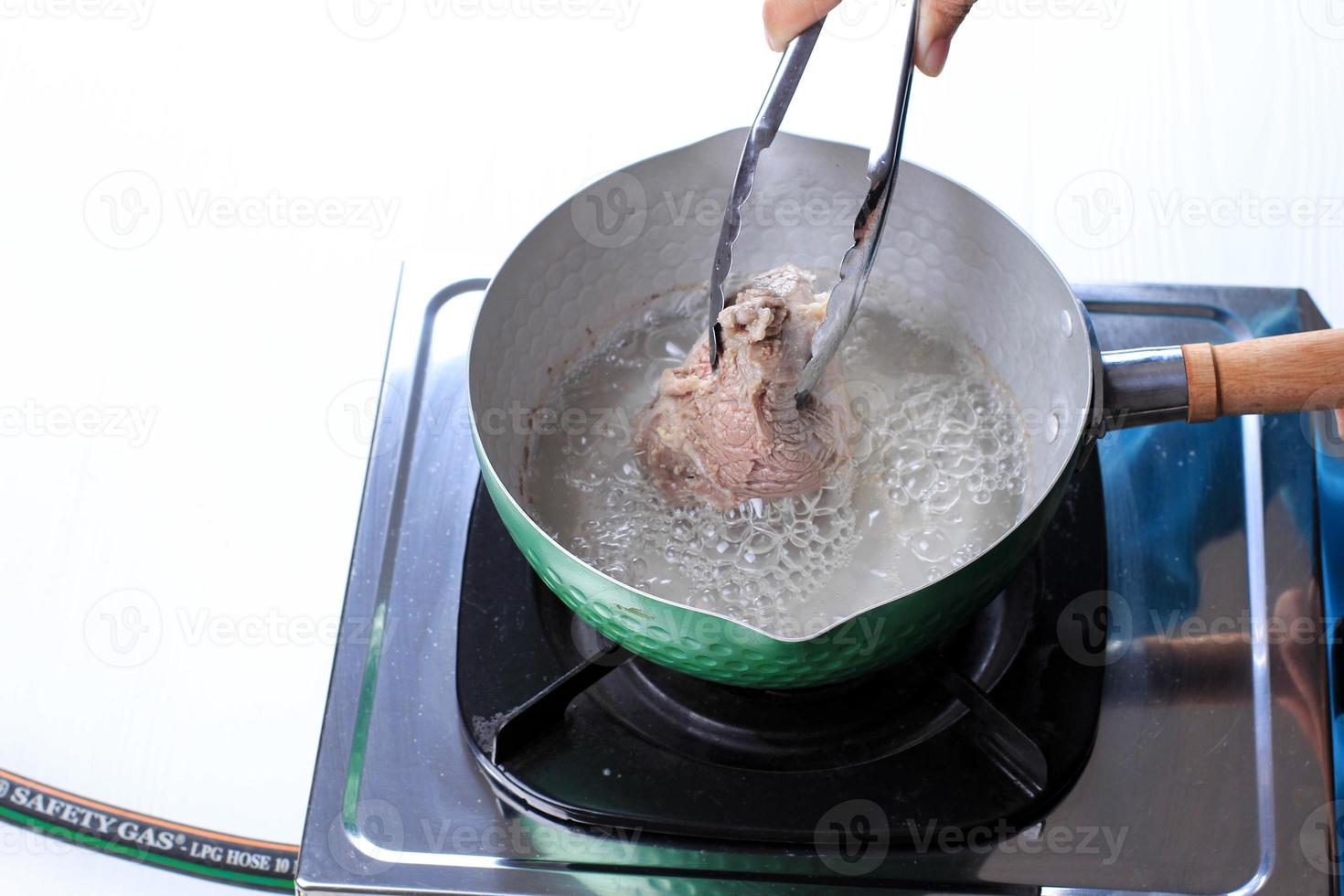 donna mano bollito Manzo su il padella foto