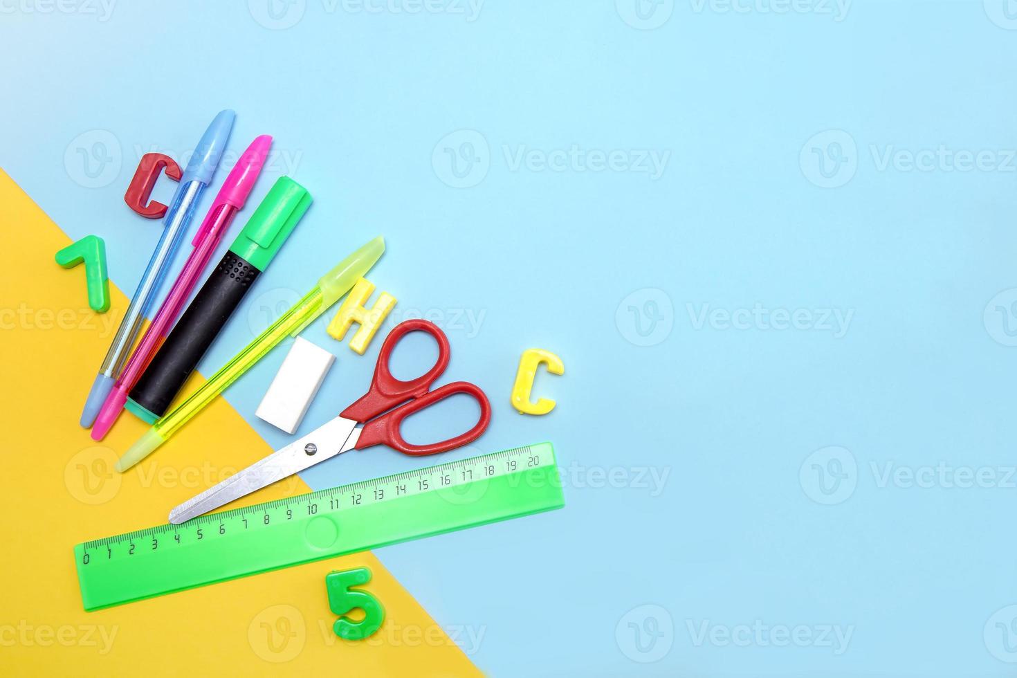 scuola forniture - governate, penne, gomma, numeri e lettere, forbici, marcatore su un' giallo-blu sfondo con copia spazio foto