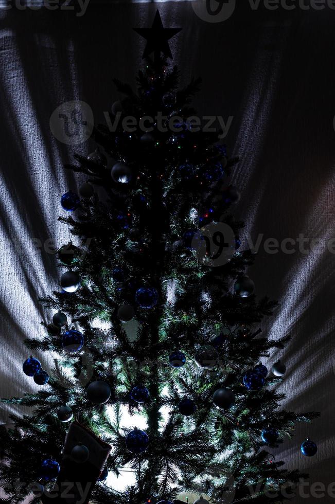 Natale albero con colorato palle e regalo scatole al di sopra di bianca mattone parete con blu e bianca palle foto