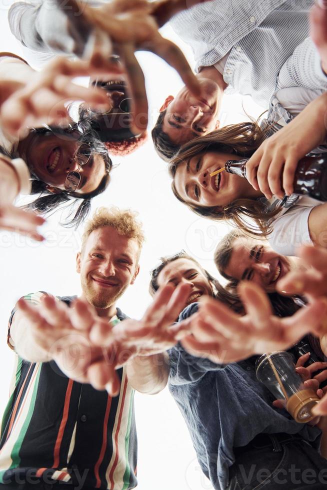 guardare fuori uso. Visualizza a partire dal sotto. gruppo di giovane persone nel casuale Abiti avere un' festa a tetto insieme a giorno foto