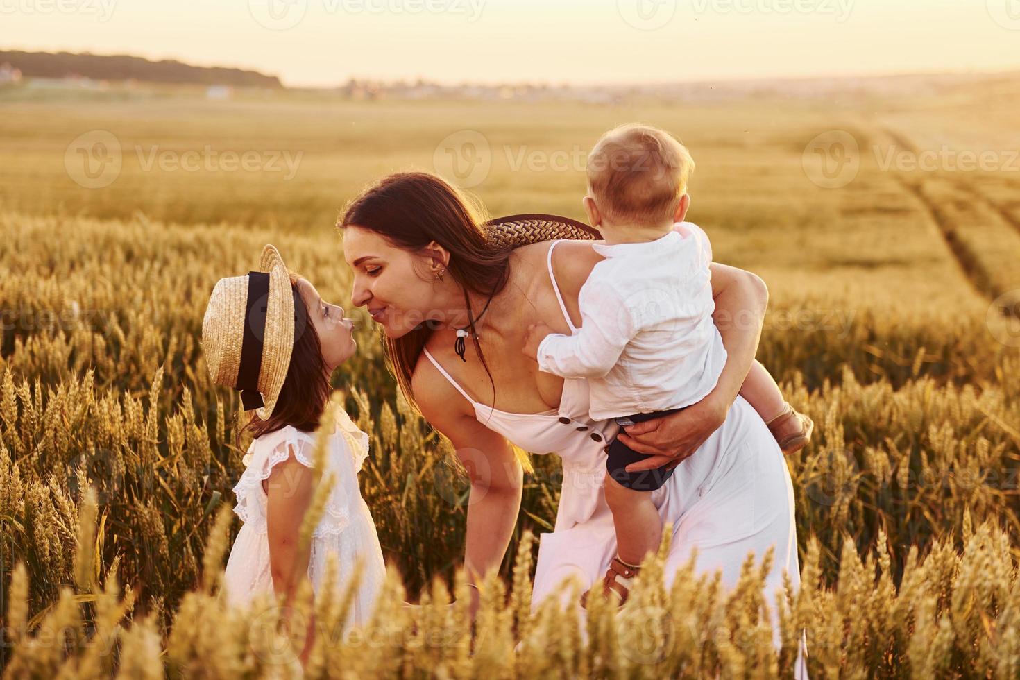 allegro famiglia di madre, poco figlio e figlia la spesa gratuito tempo su il campo a soleggiato giorno tempo di estate foto