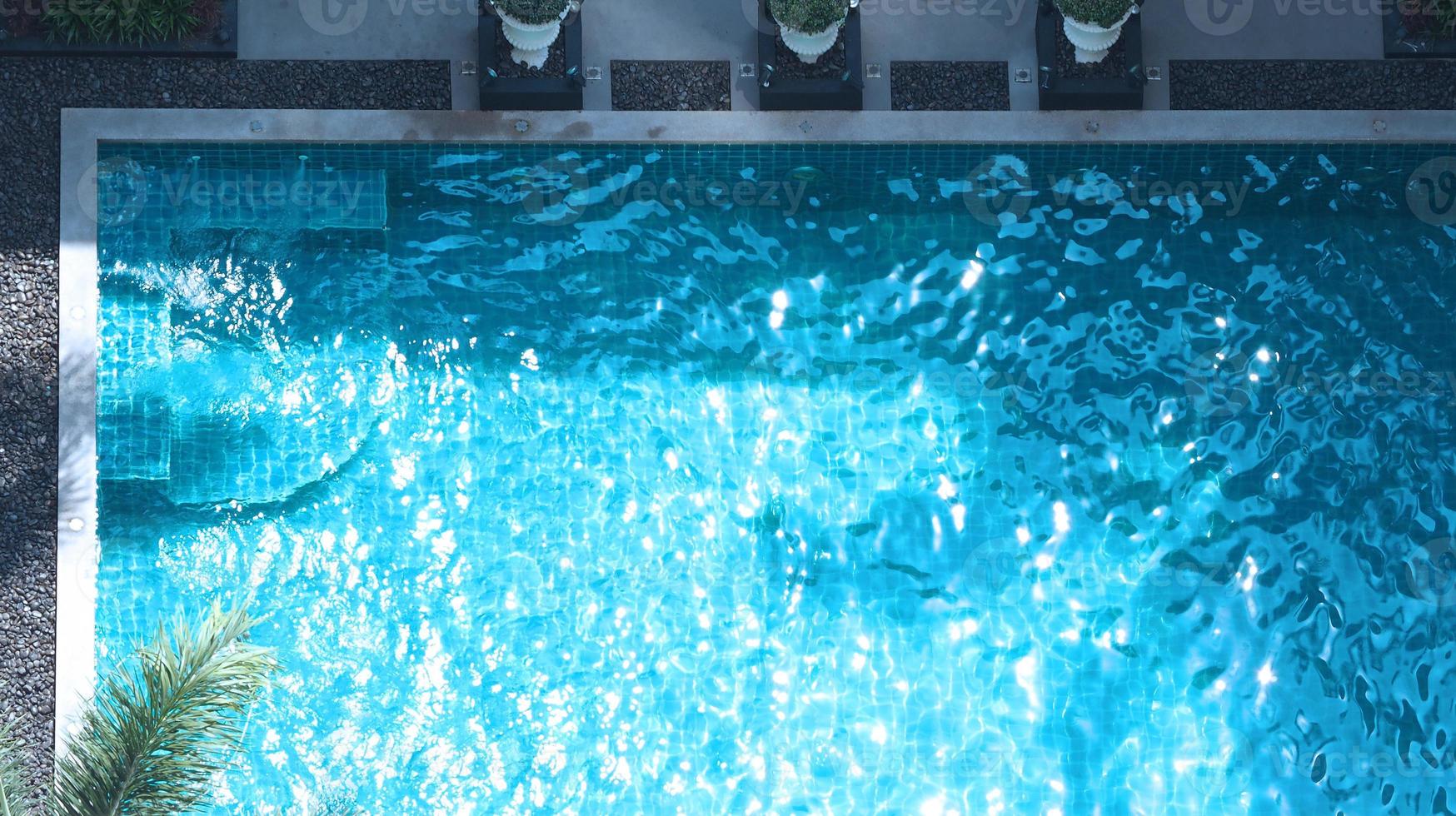 nuoto piscina blu acqua nel estate e bianca spiaggia letti e superiore Visualizza angolo. foto