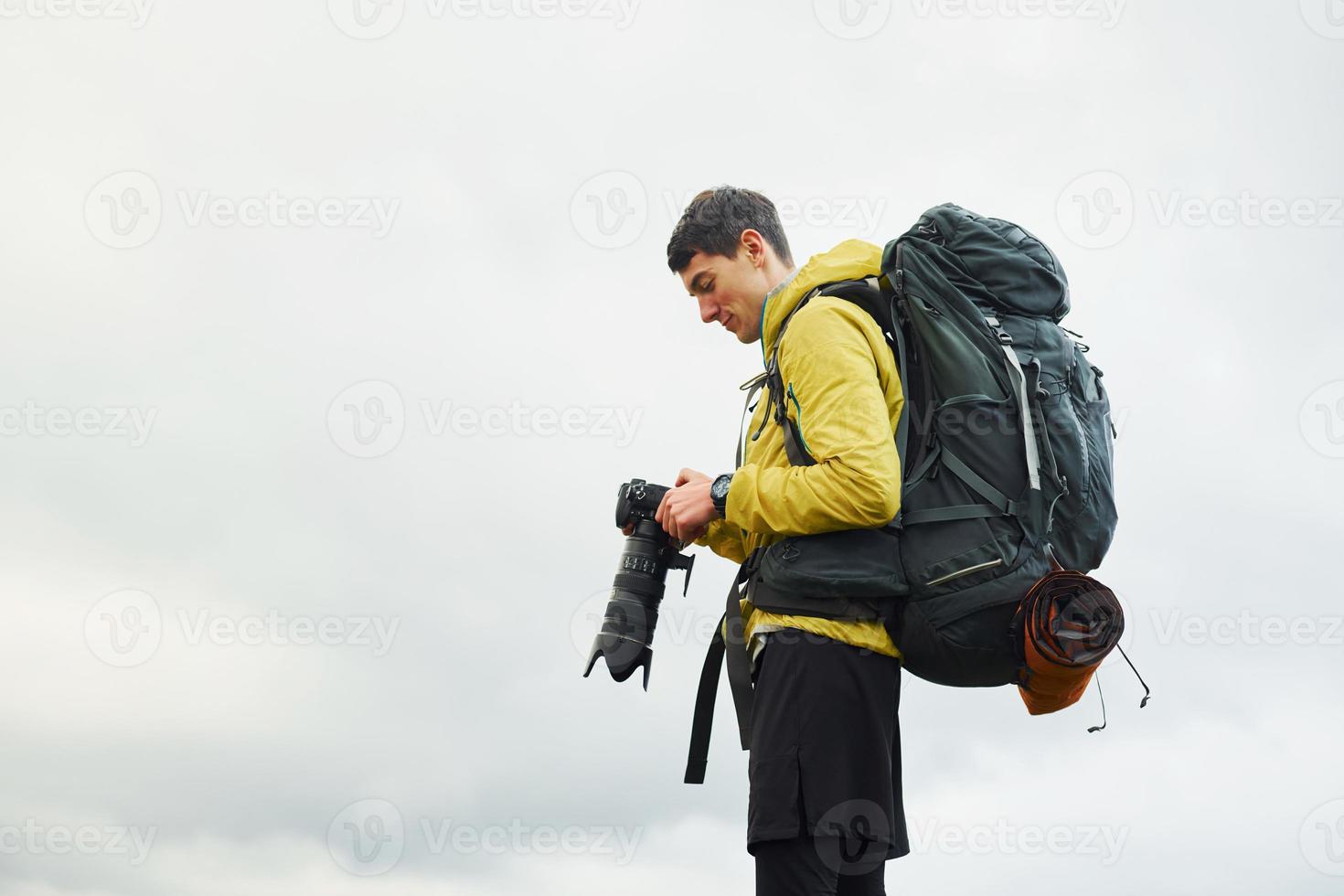 giovane maschio fotografo con il suo professionale telecamera assunzione immagini di bellissimo natura foto
