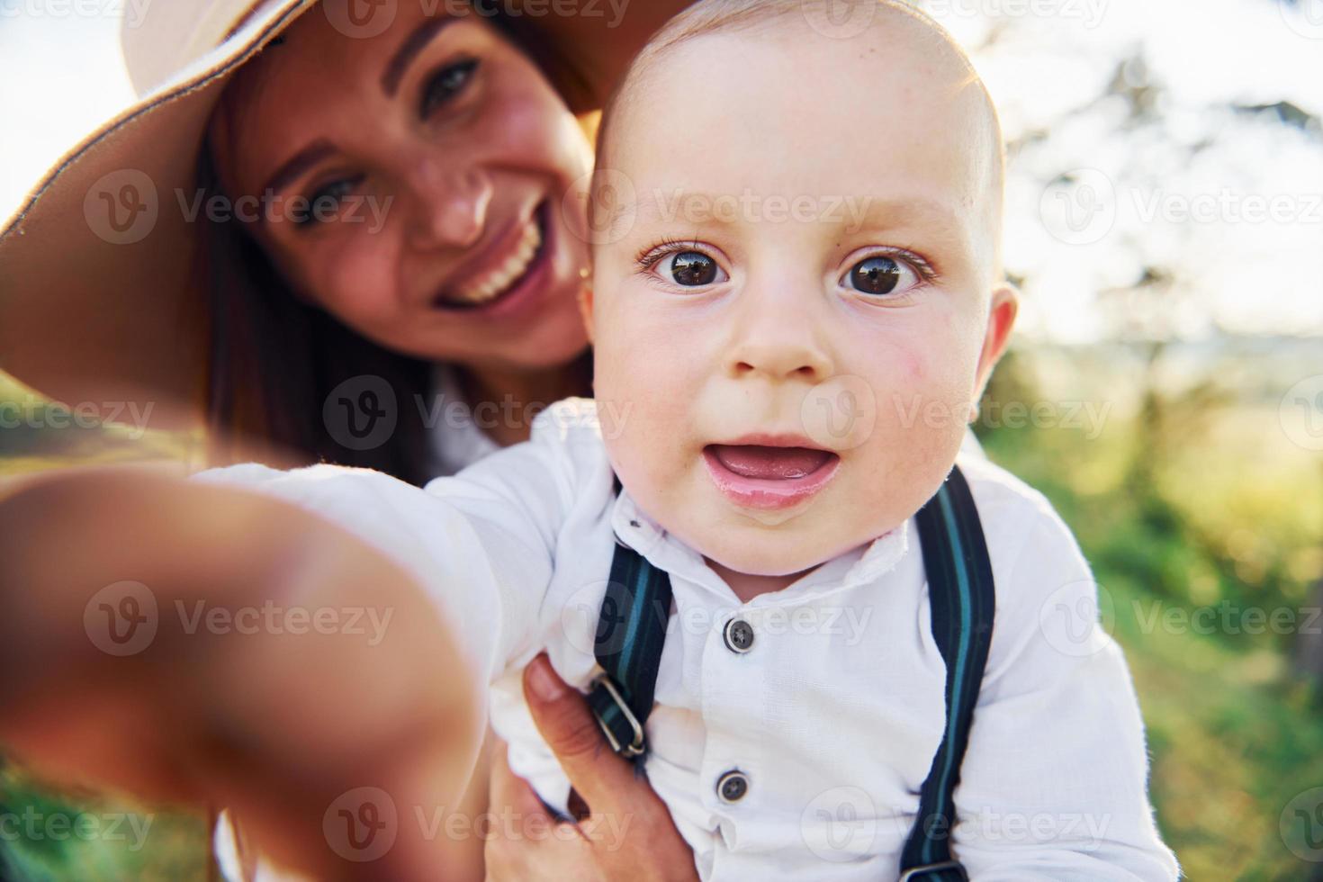 giovane madre con sua poco figlio è all'aperto nel il foresta. bellissimo luce del sole foto