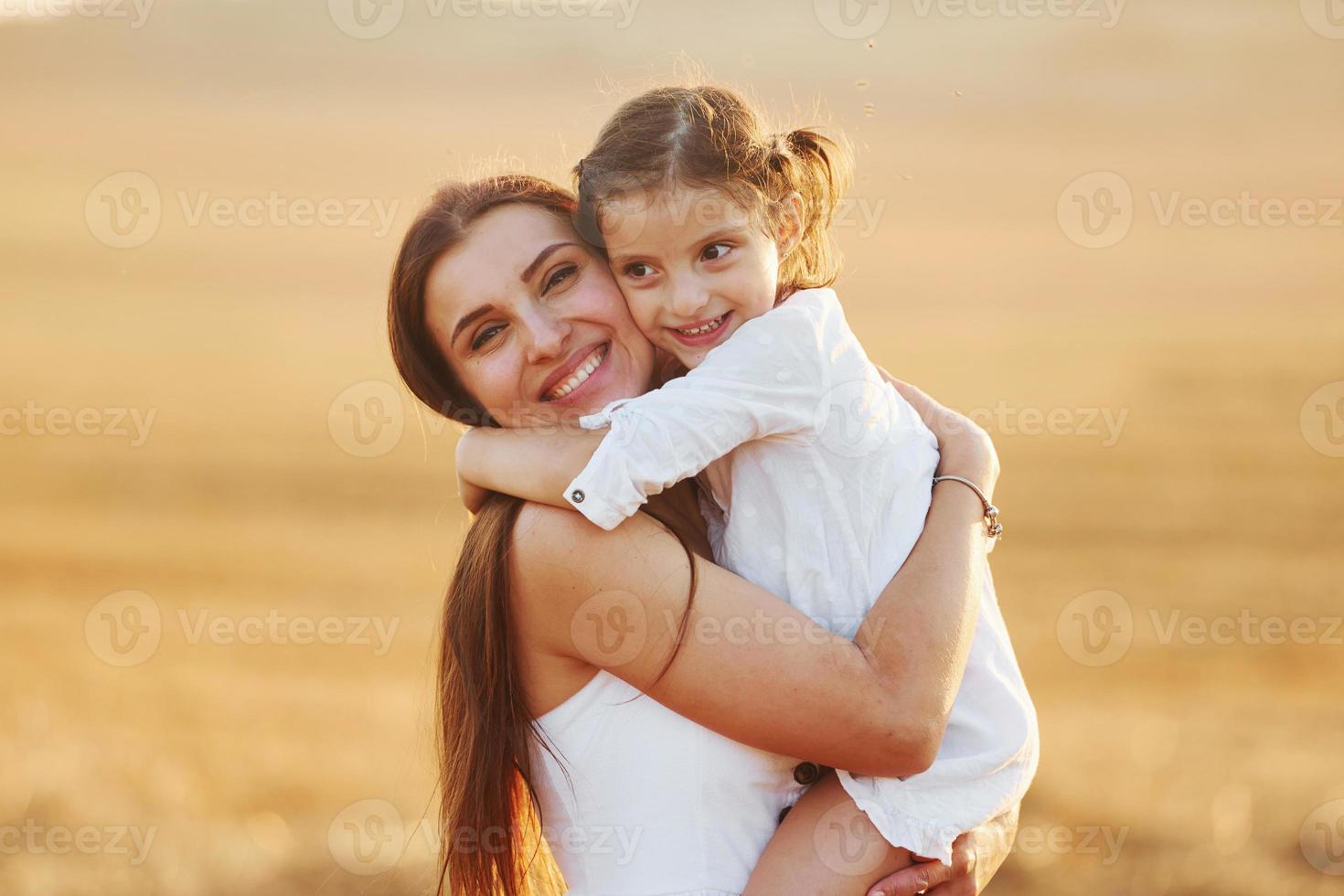 contento madre con sua poco figlia la spesa tempo insieme all'aperto su il campo foto