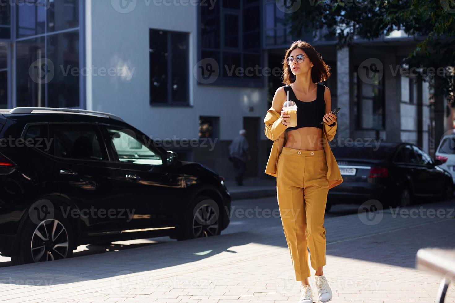 giovane alla moda donna nel Borgogna colorato cappotto a giorno con sua auto foto