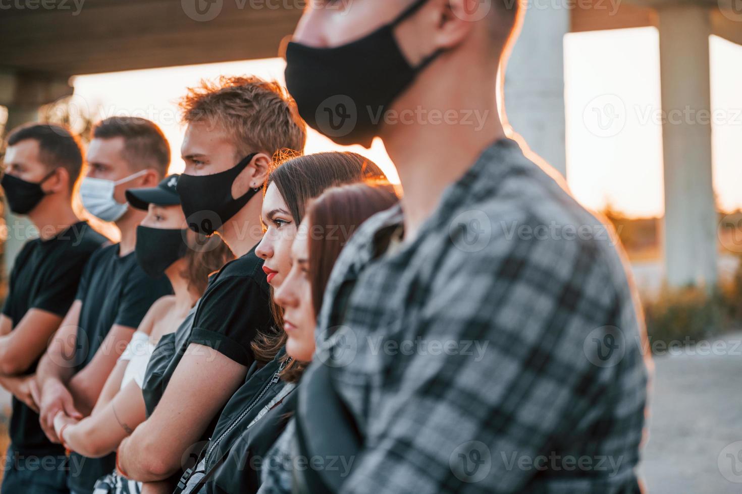 bellissimo luce del sole. gruppo di protestare giovane persone quello in piedi insieme. attivista per umano diritti o contro governo foto