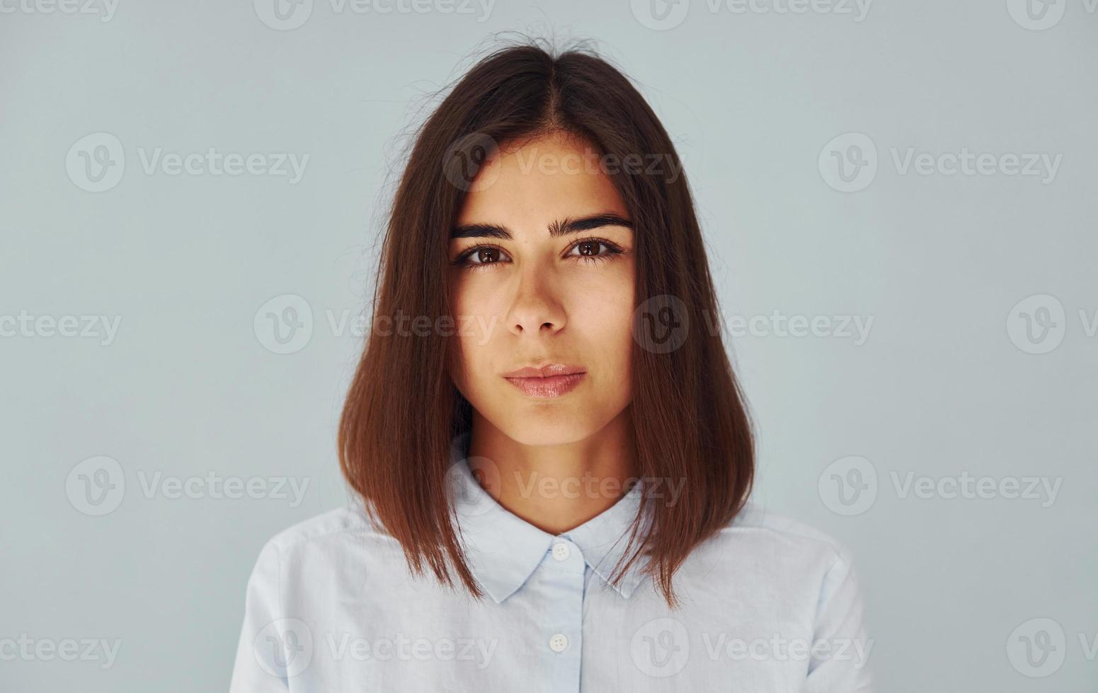 giovane moderno donna nel bianca camicia in piedi dentro di il studio foto