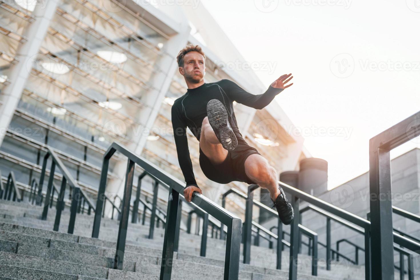 fa parkour. giovane uomo nel allegro Abiti avere allenarsi all'aperto a giorno foto