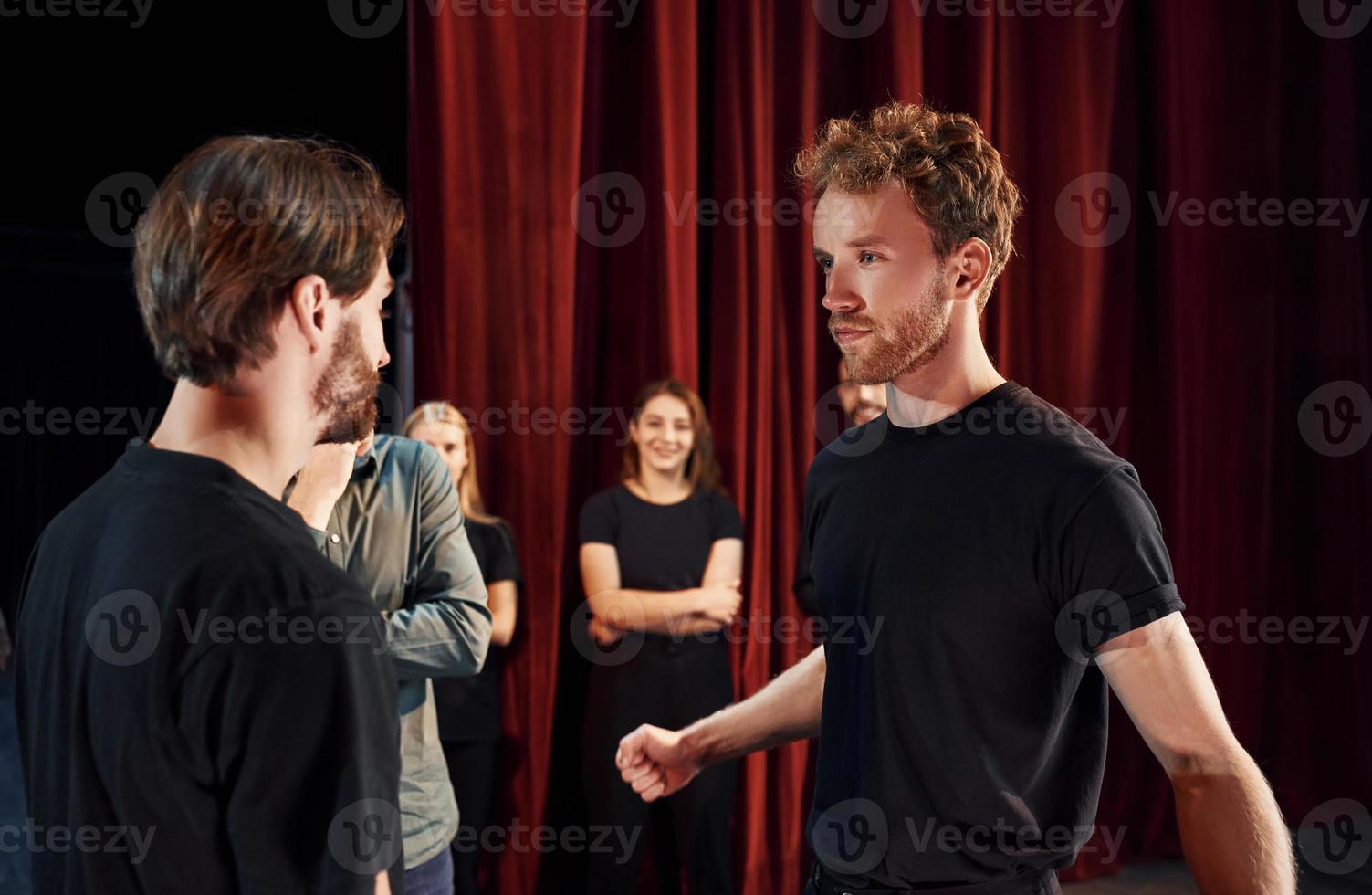 Due persone parlando. gruppo di attori nel buio colorato Abiti su prova nel il Teatro foto