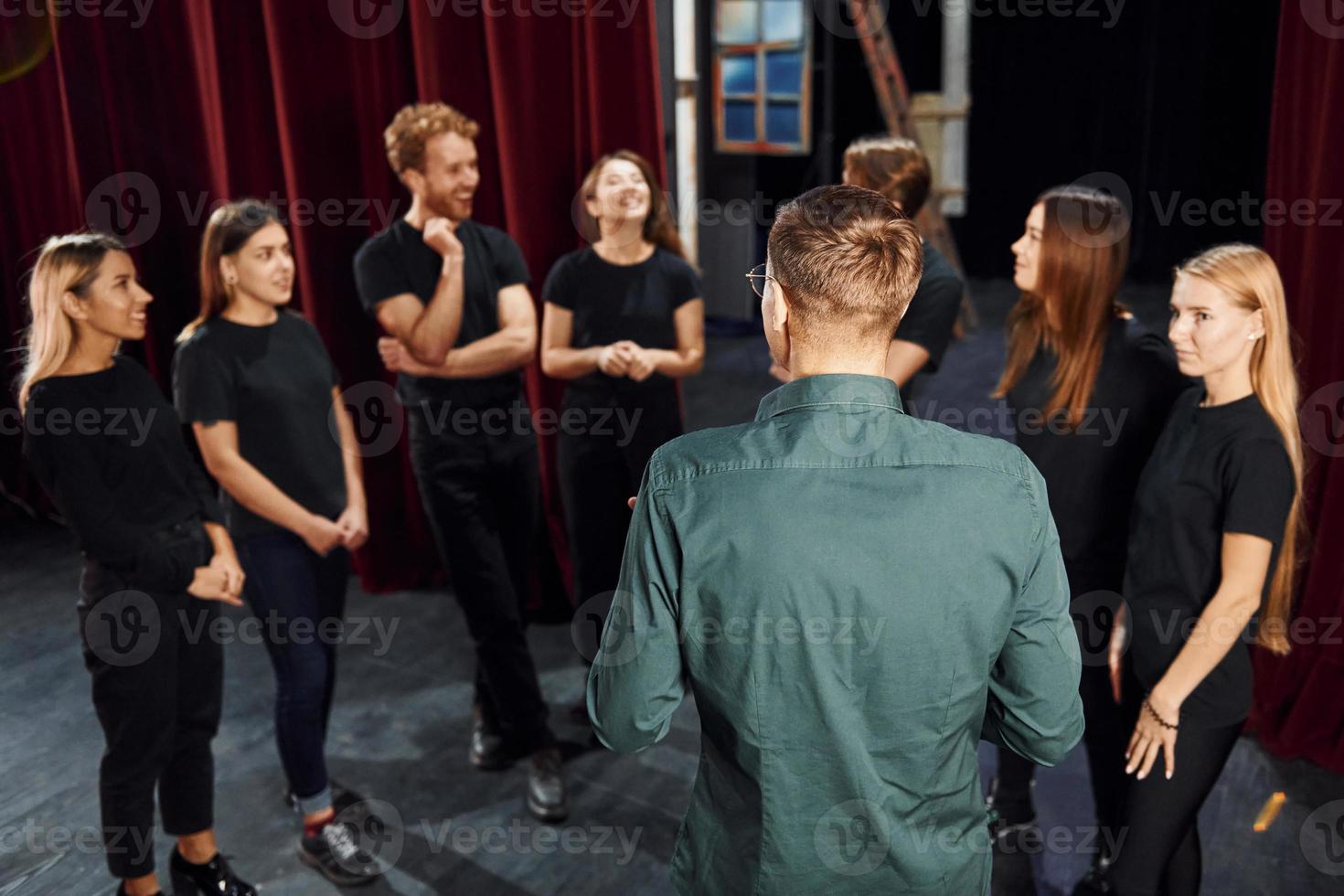 Lavorando insieme. gruppo di attori nel buio colorato Abiti su prova nel il Teatro foto