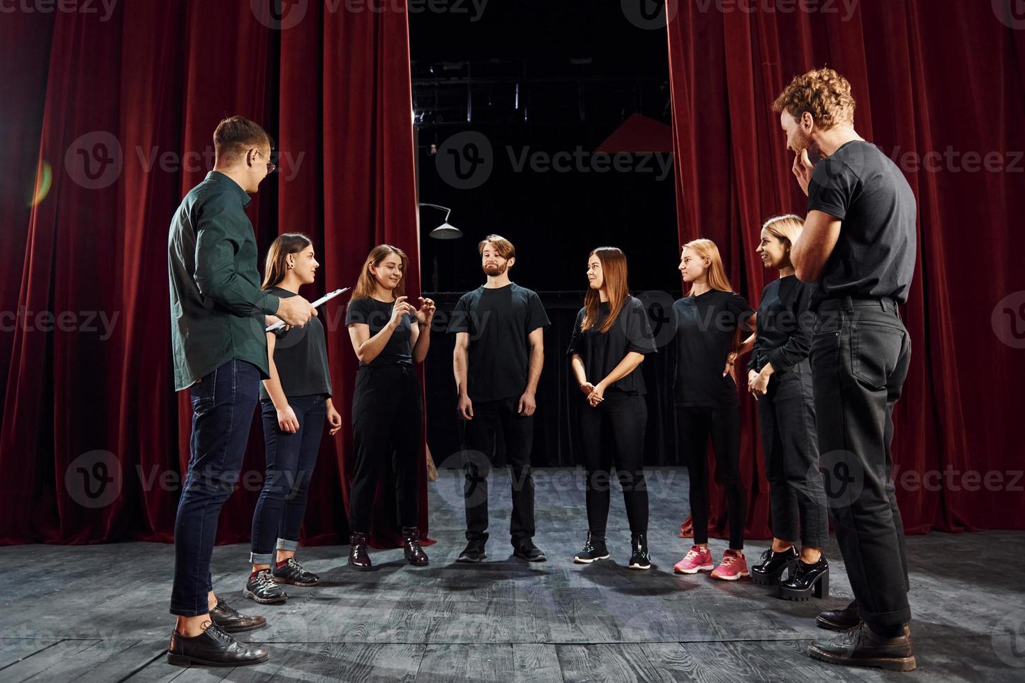 Lavorando insieme. gruppo di attori nel buio colorato Abiti su prova nel il Teatro foto