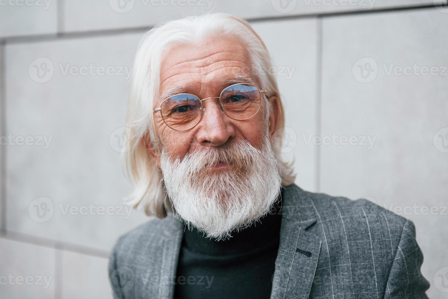 ritratto di anziano uomo d'affari nel formale Abiti, con grigio capelli e barba quello in piedi all'aperto foto