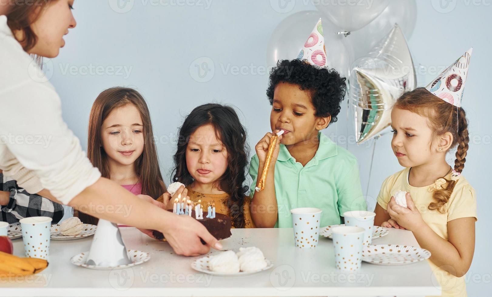 donna detiene torta. bambini su festeggiare compleanno festa in casa avere divertimento insieme foto