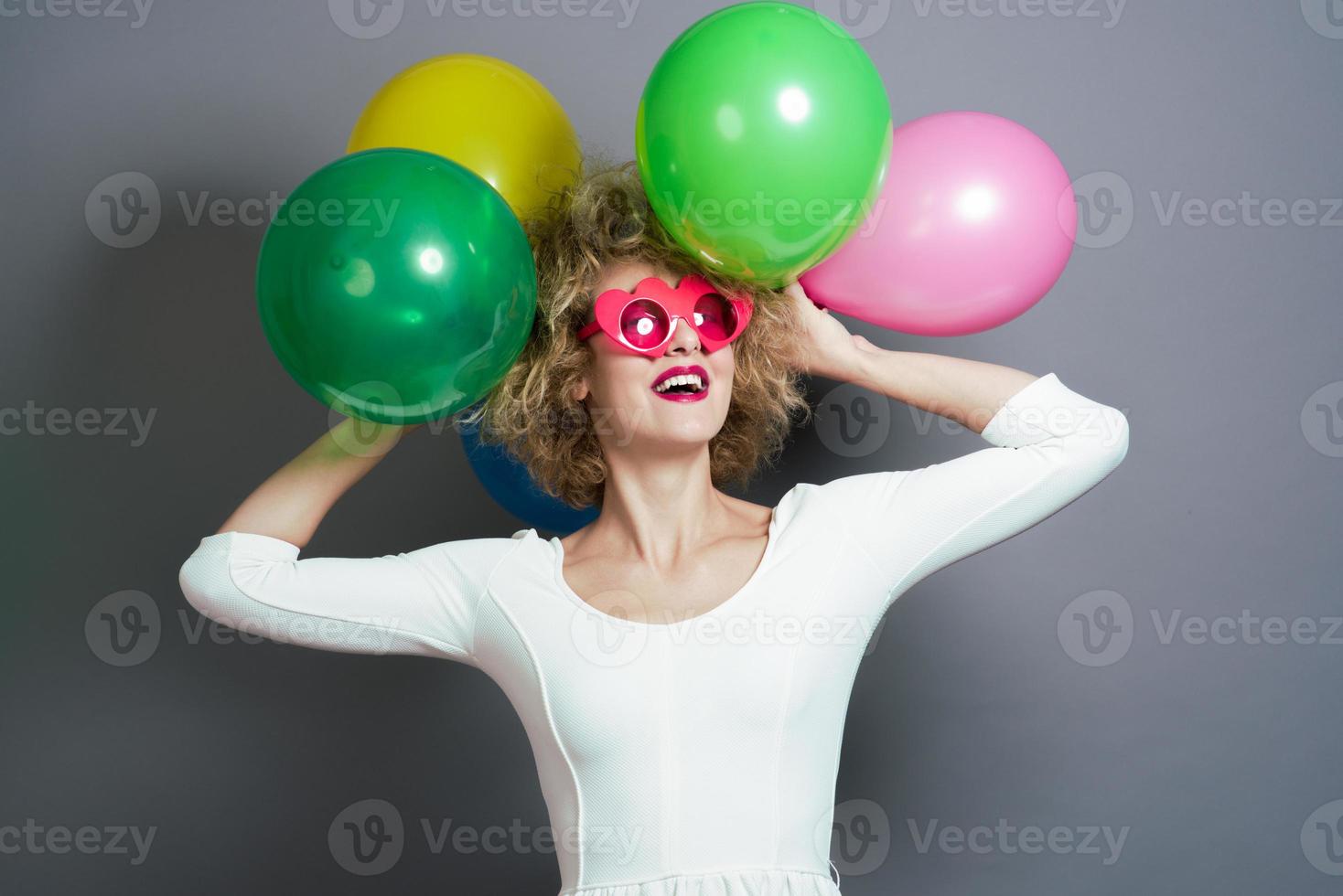 bellissimo bionda femmina modello Tenere palloncini in giro sua testa. isolato foto