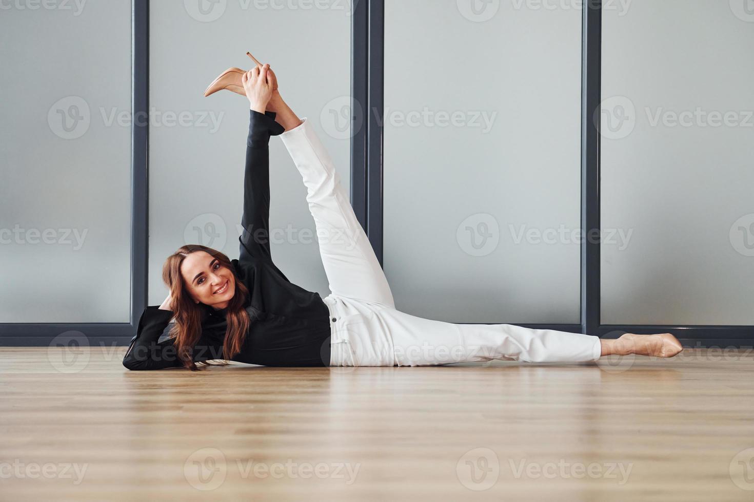 giovane donna nel formale Abiti è in casa su il pavimento a giorno foto