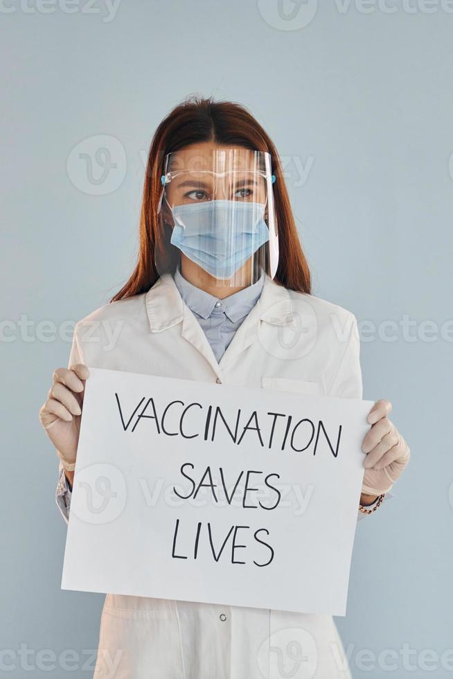 vaccinazione salva vite striscione. giovane femmina medico nel bianca cappotto foto