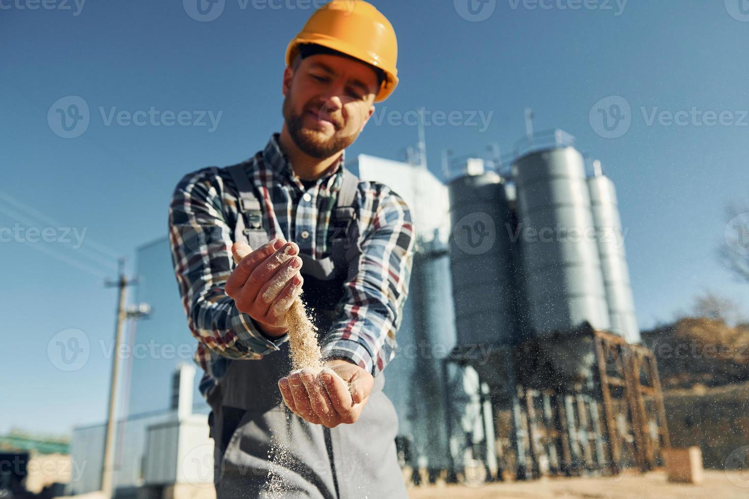 Tenere suolo. costruzione lavoratore nel uniforme è all'aperto vicino il fabbrica foto