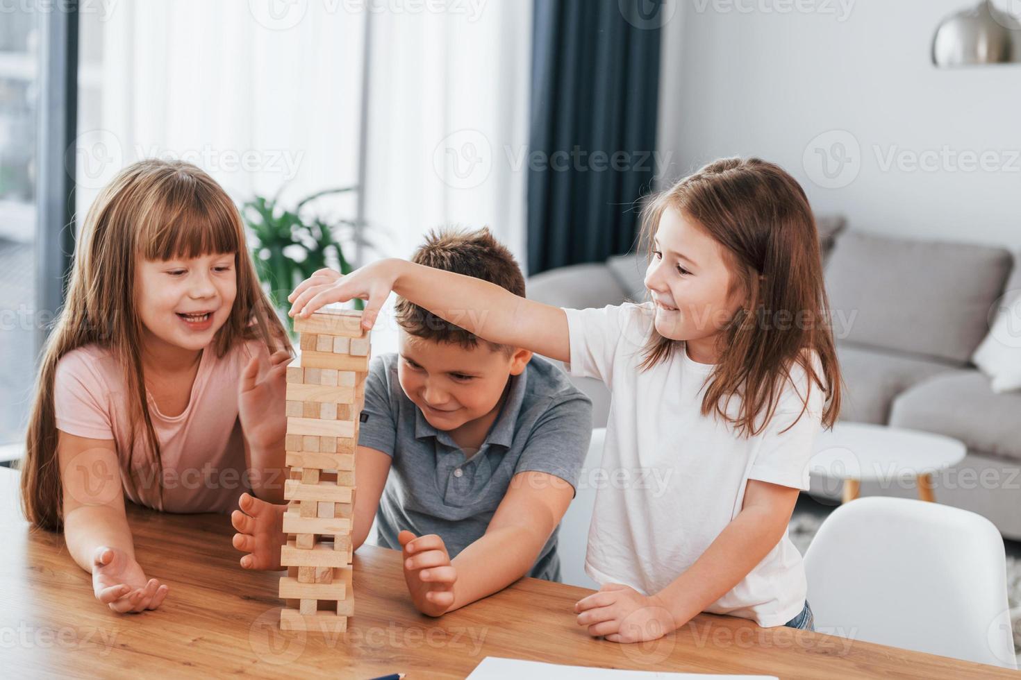 confusione Torre gioco. bambini avendo divertimento nel il domestico camera a giorno insieme foto