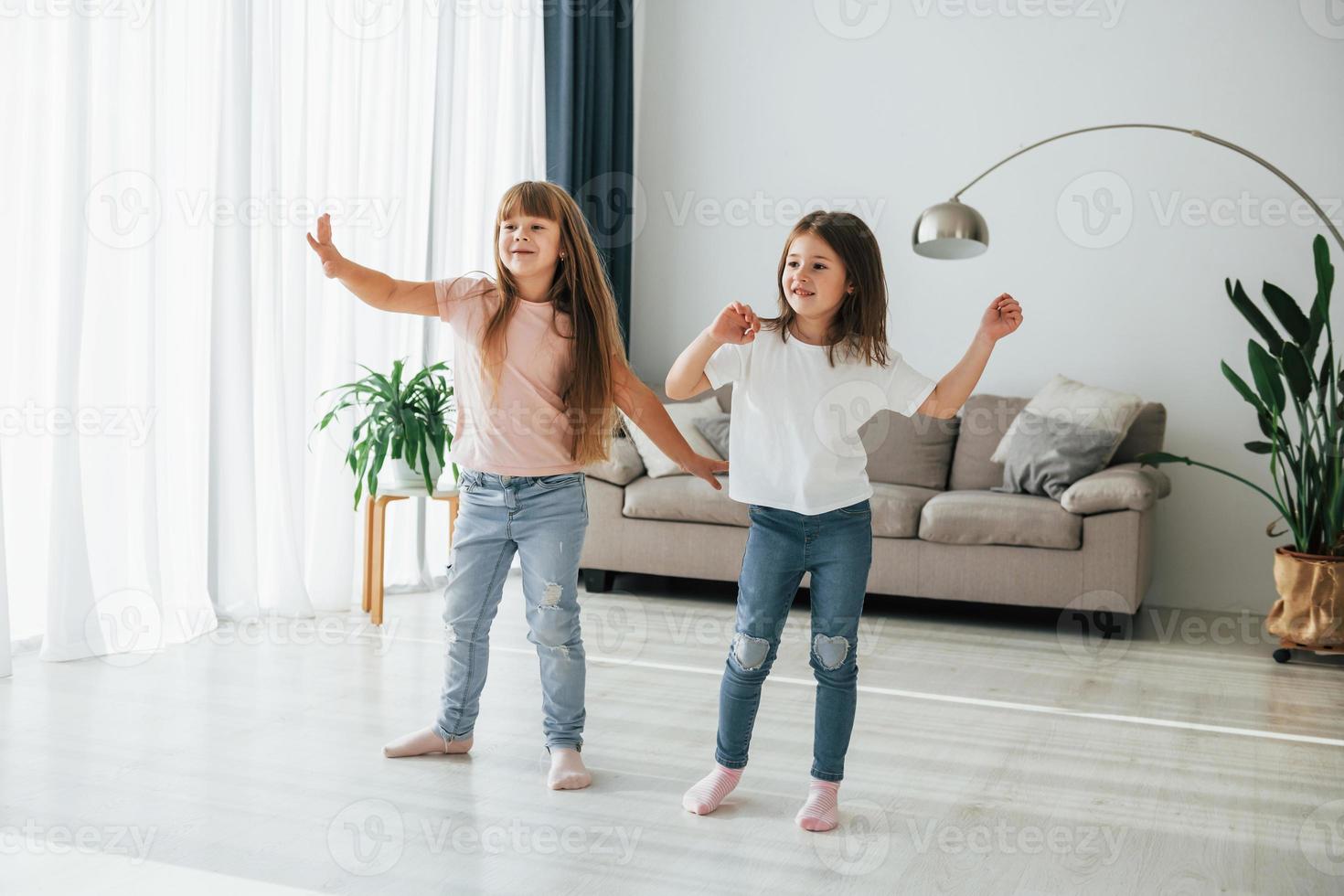 danza insieme. bambini avendo divertimento nel il domestico camera a giorno foto