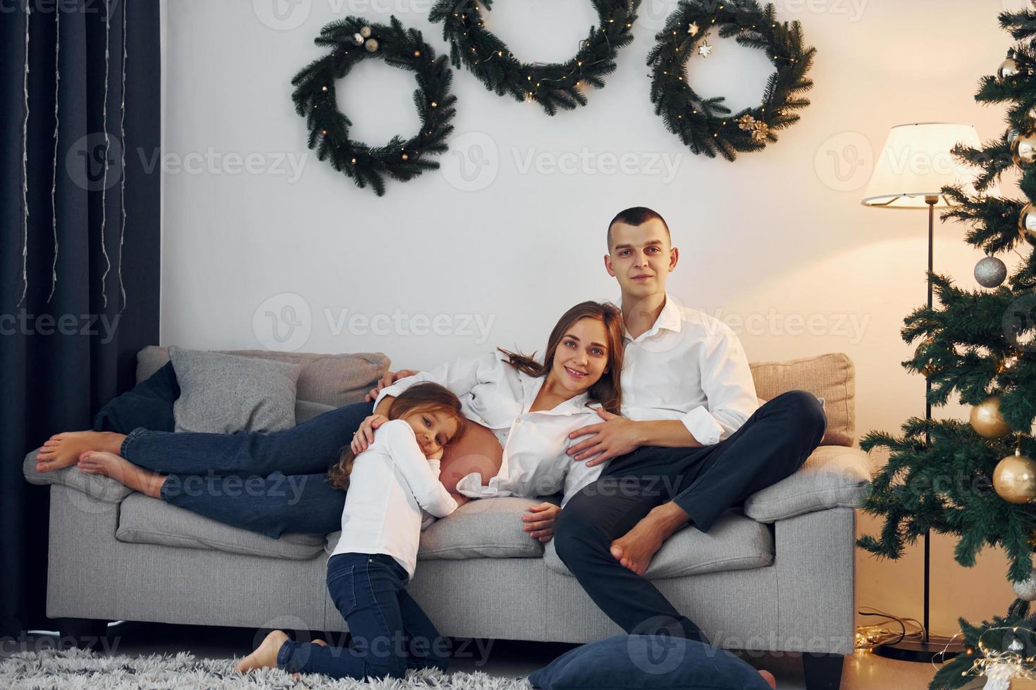 con Natale albero. contento famiglia festeggiare vacanze in casa insieme foto