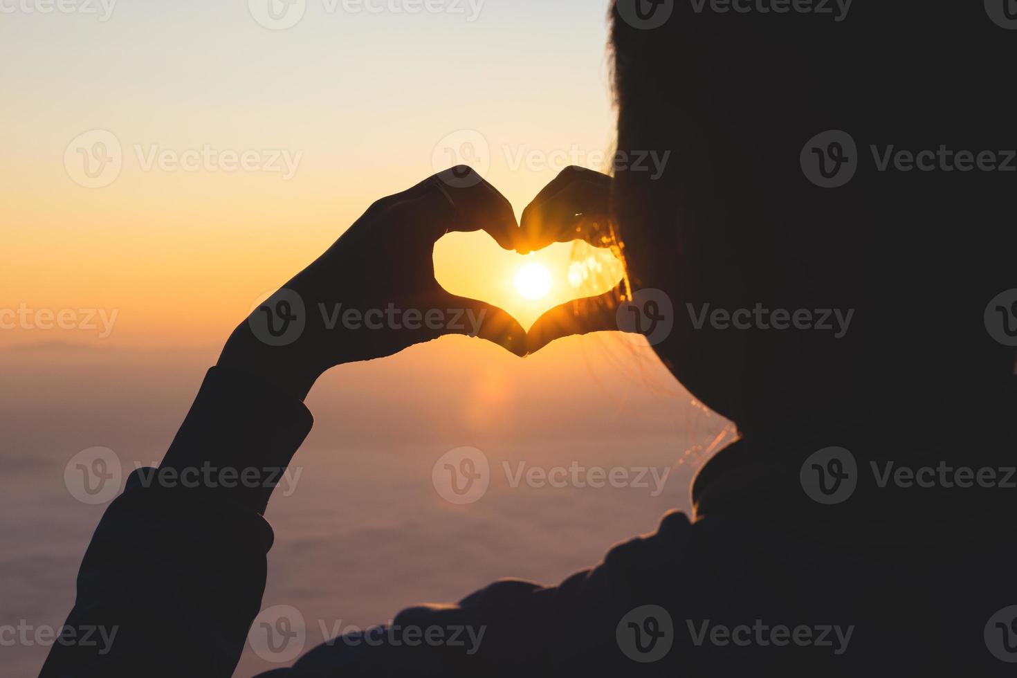 silhouette. donna formatura un' cuore forma durante Alba. Dio è amore concetto. cuore forma. montagna turismo. mostrando amore amore e sentimenti, dedizione e speranza. foto