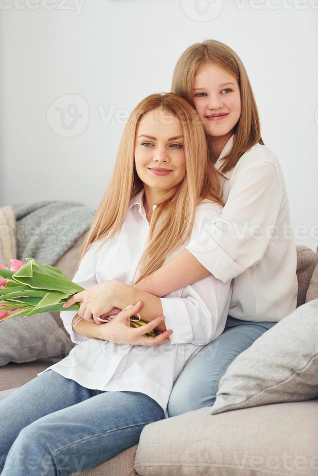 fiori a vacanza. giovane madre con sua figlia è a casa a giorno foto