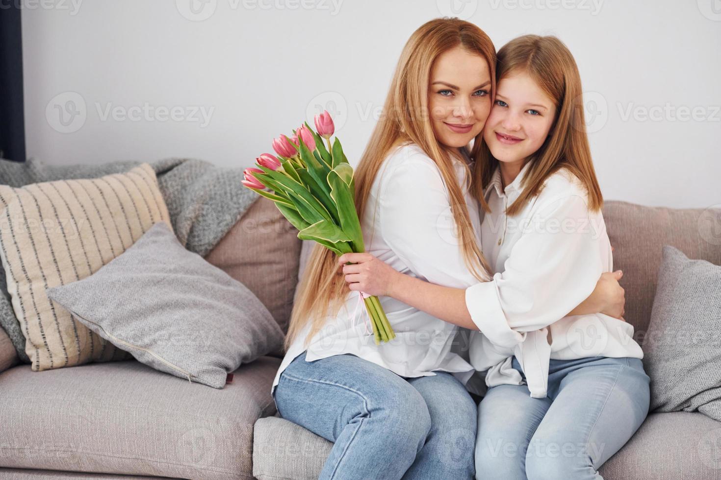 fiori a vacanza. giovane madre con sua figlia è a casa a giorno foto